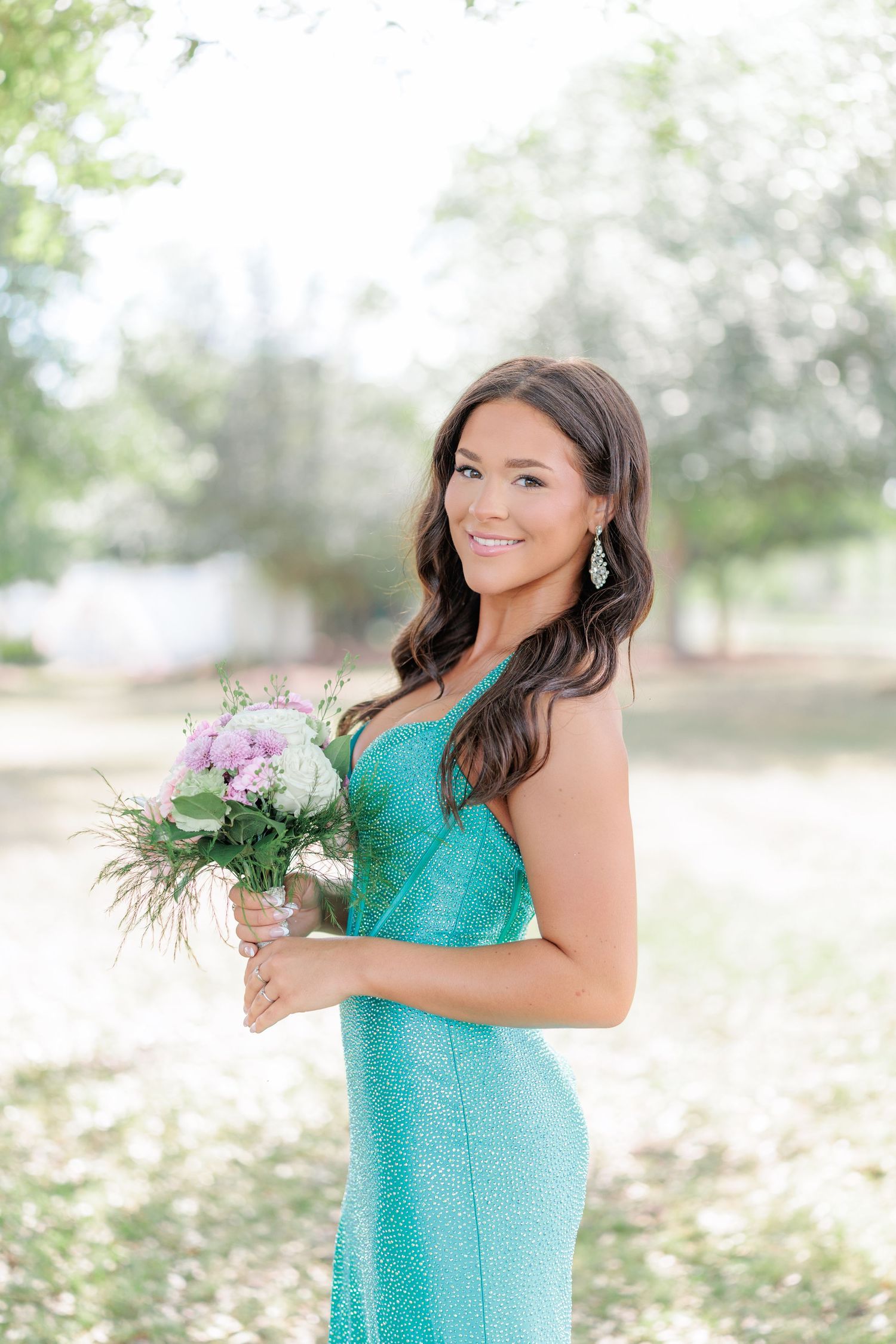 Beautiful portrait of a high school girl in her elegant prom dress holding a floral arrangement, taken by a photographer in Valdosta, GA.
