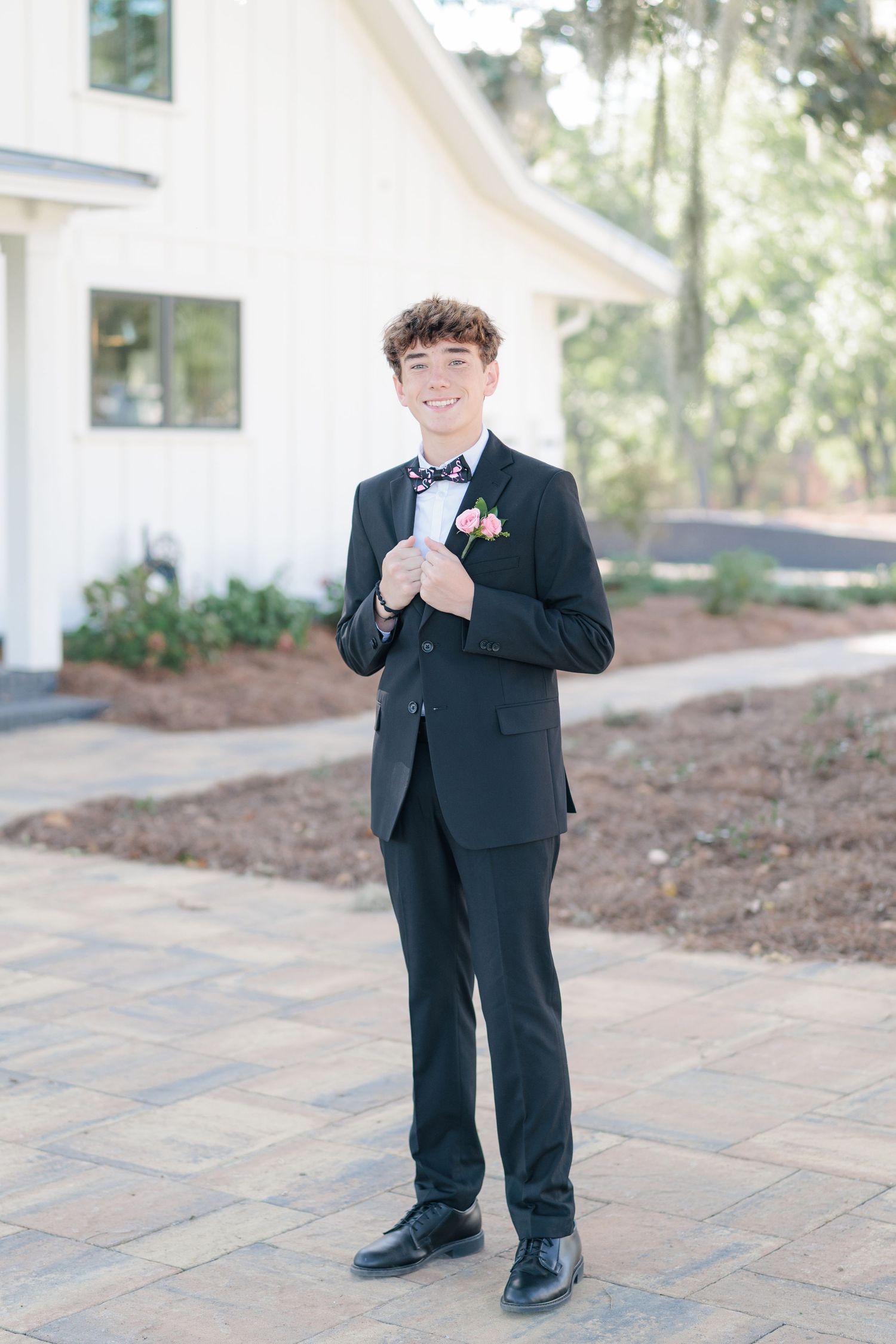 Sharp portrait of a high school guy dressed in a classic prom attire with a boutonniere, taken by a photographer based in Valdosta, GA.