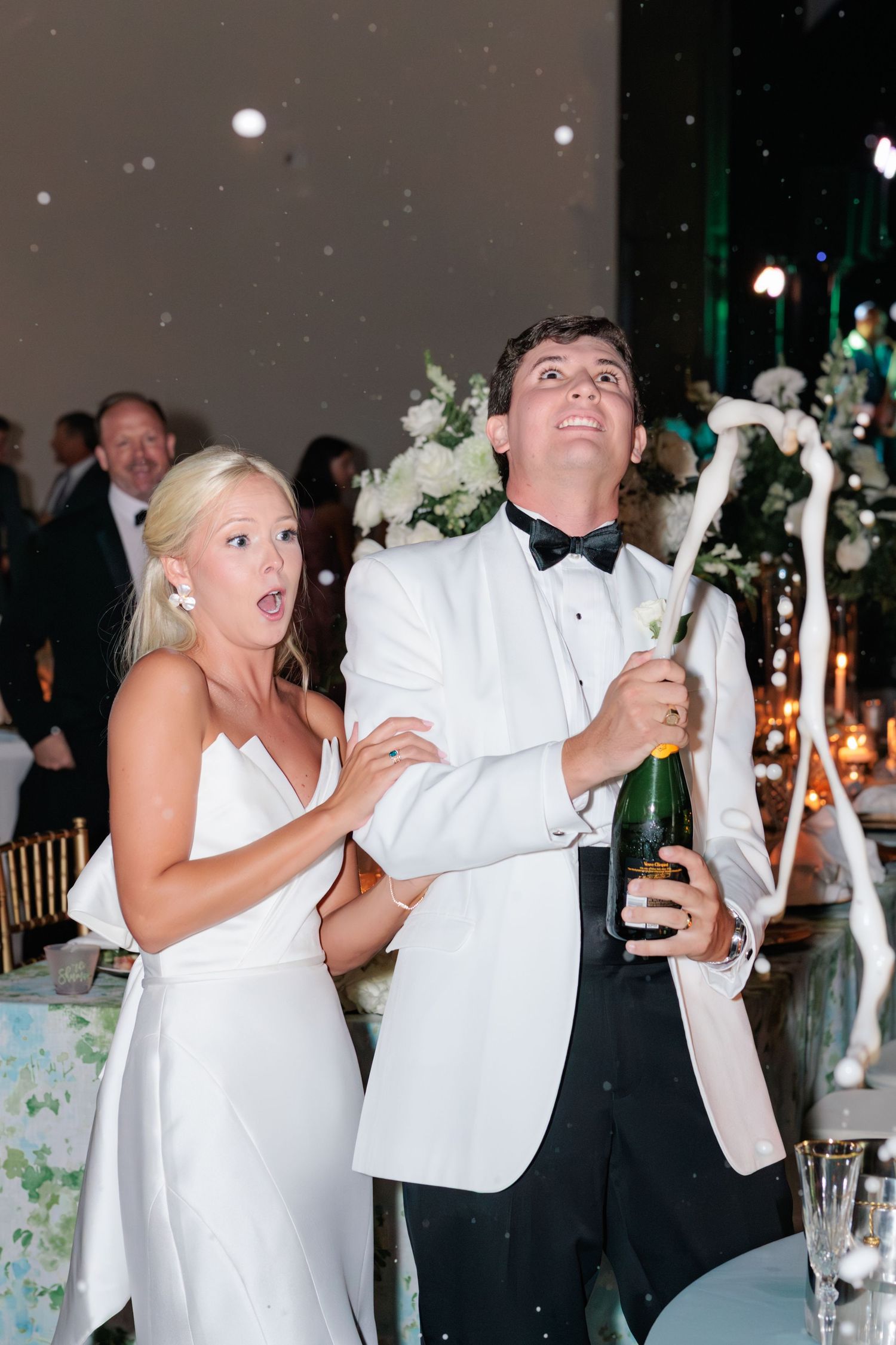 Couple popping a champaign bottle at their wedding reception in Waycross, Georgia. Taken by a photographer based in Valdosta, Georgia.