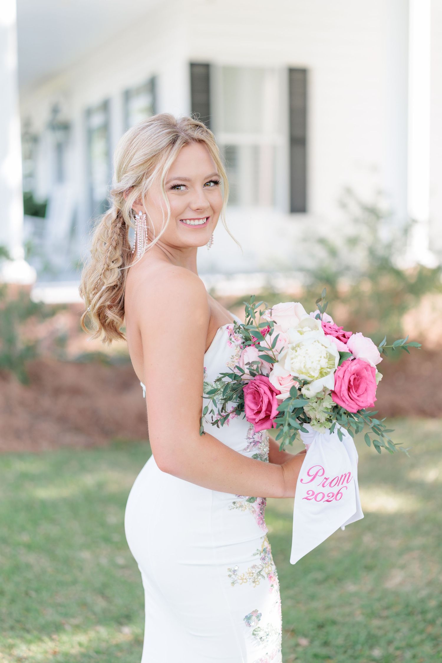 Beautiful portrait of a high school girl in her elegant prom dress holding a floral arrangement, taken by a photographer in Valdosta, GA.