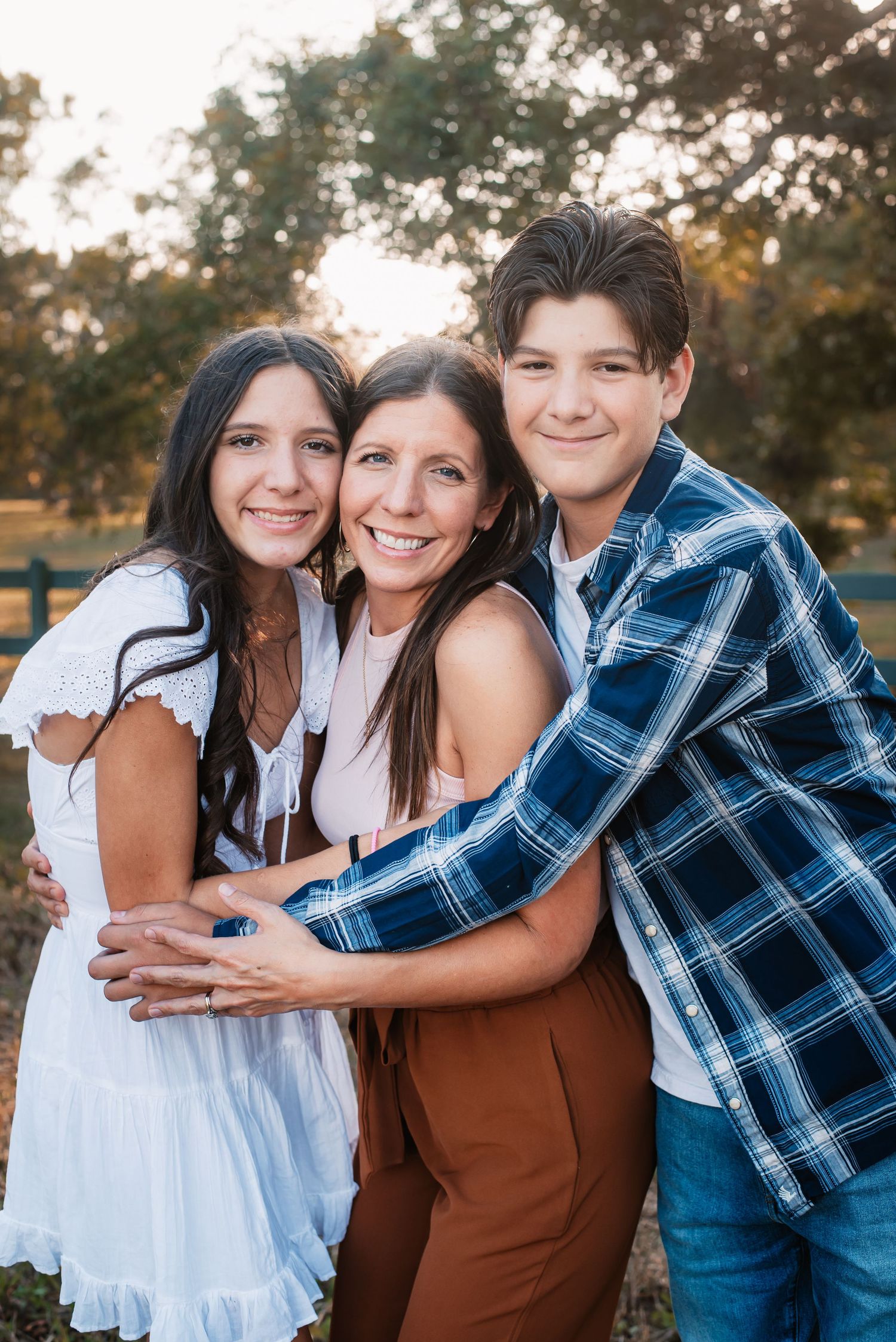 Kids hugging their mother and smiling at their outdoor photography photo session in Fulshear, TX.