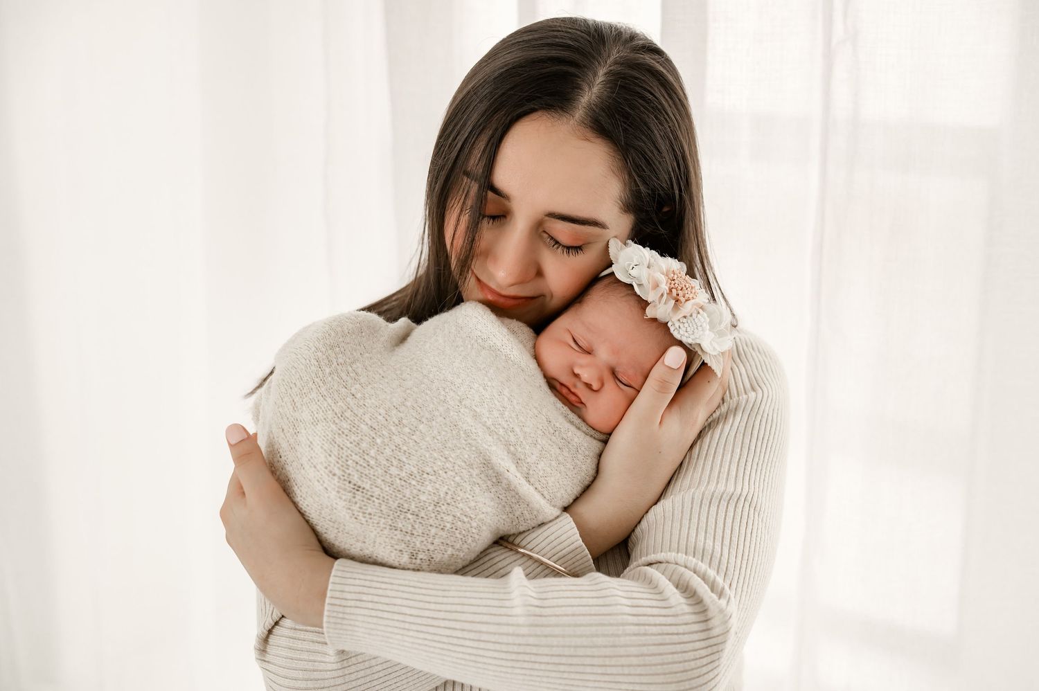 Mom snuggling newborn in a relaxed baby led studio photography session