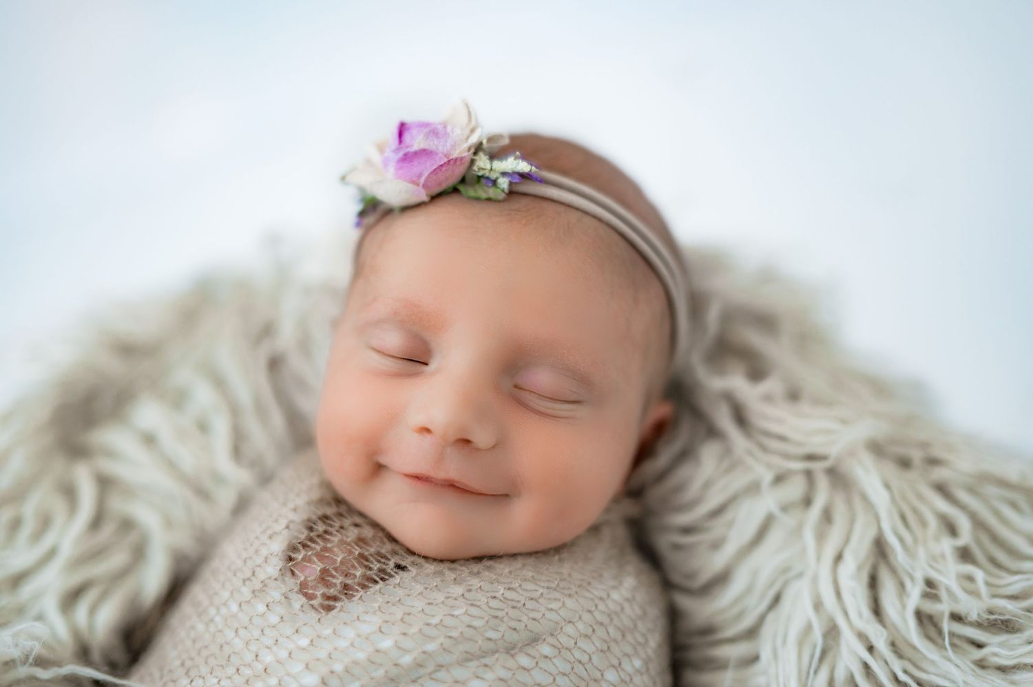 Smiling newborn in prop in Fulshear TX.