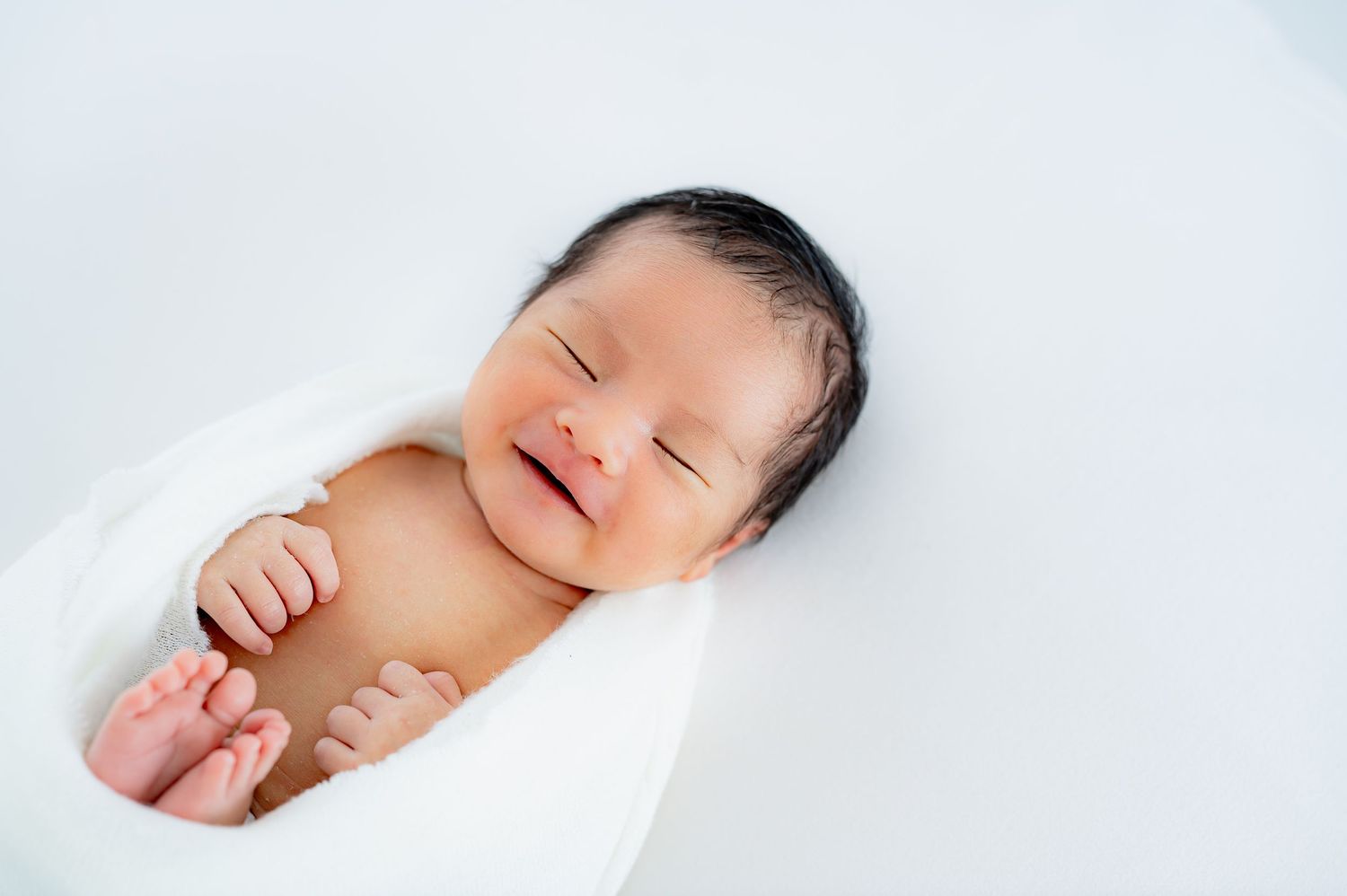 Smiling newborn during a baby-led neutral studio newborn session in Fulshear TX