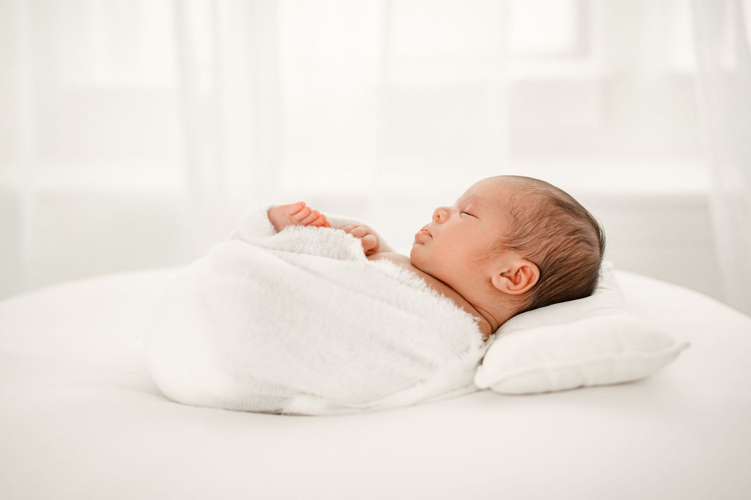 Sleeping wrapped newborn baby during studio session in Katy TX