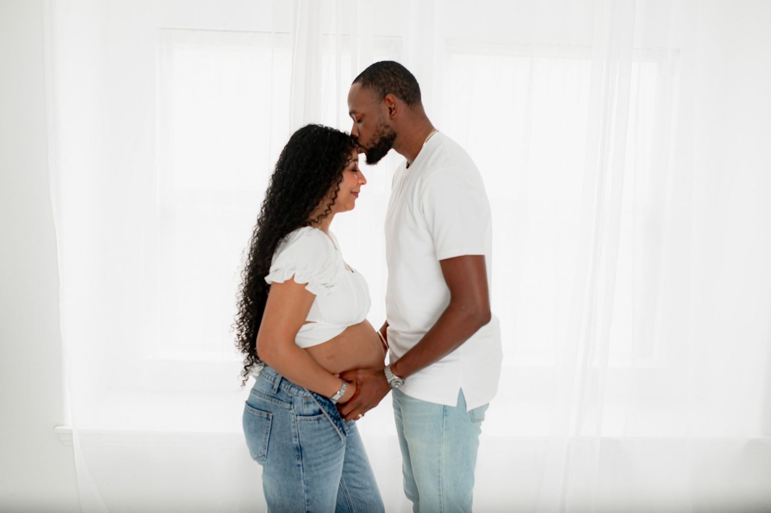 A special moment sealed with an embrace of the belly and kiss in Fulshear, TX studio maternity session.
