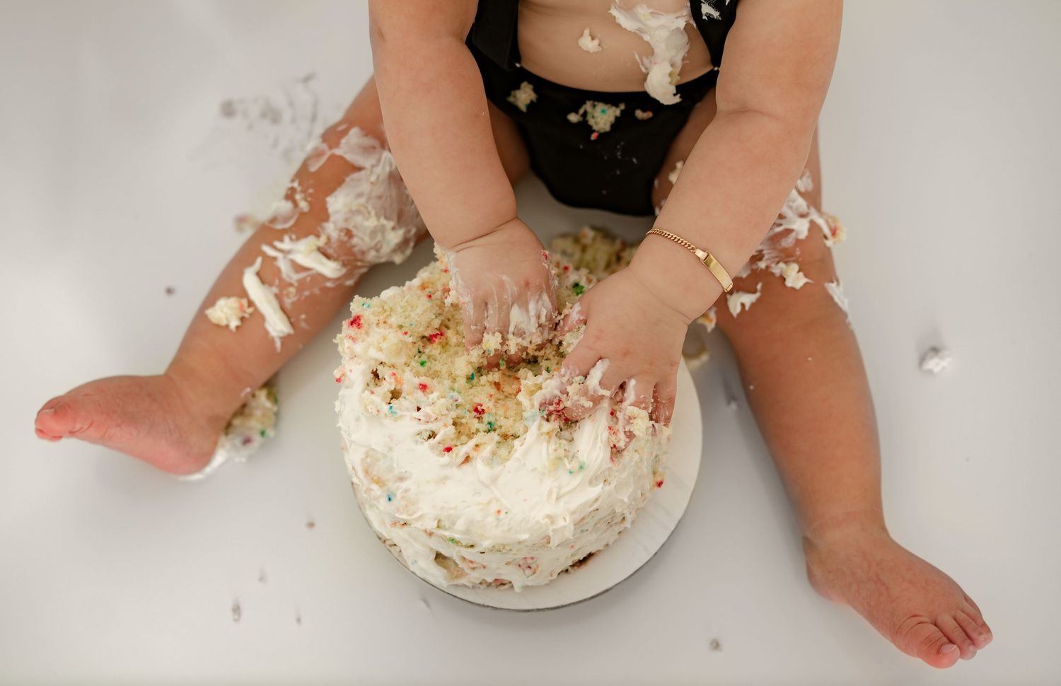 Hands in cake during cake smash session in Fulshear Texas