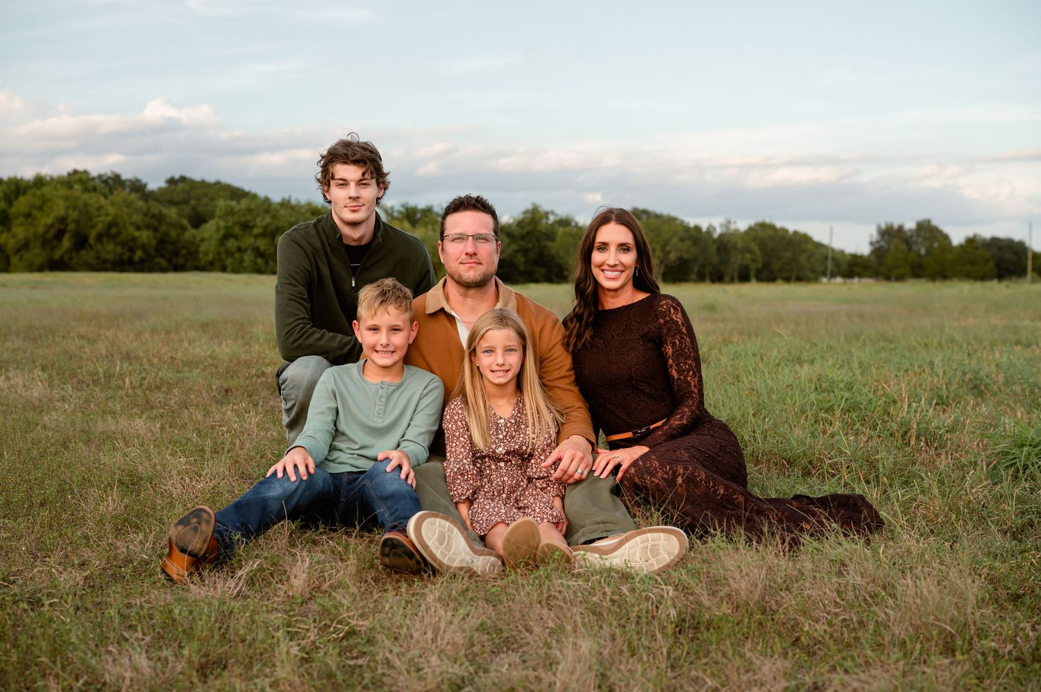 Family posing in an open field in Katy, TX for an outdoor photo session.