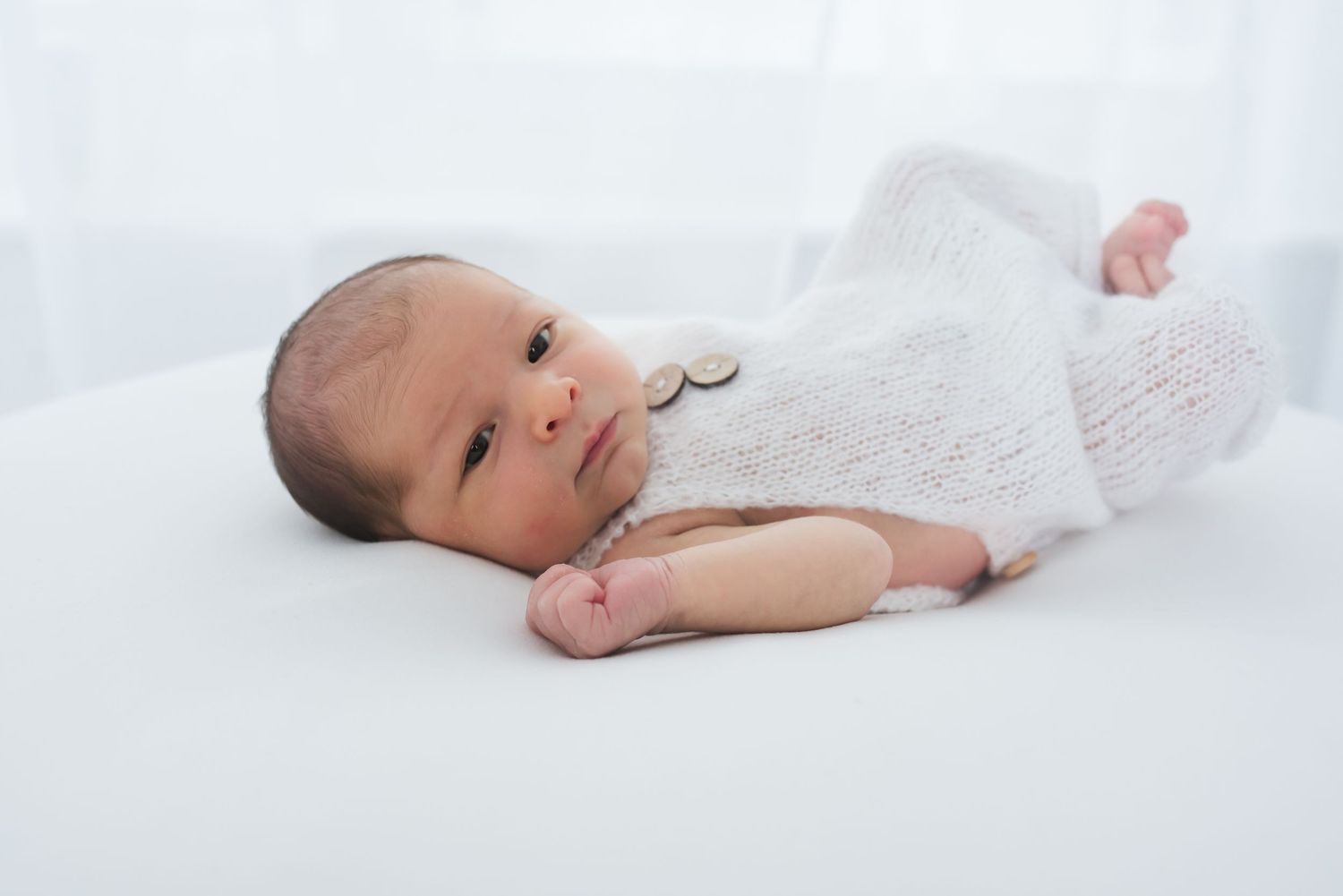 Awake newborn baby looking at the camera during his newborn photography session in Fulshear, TX.