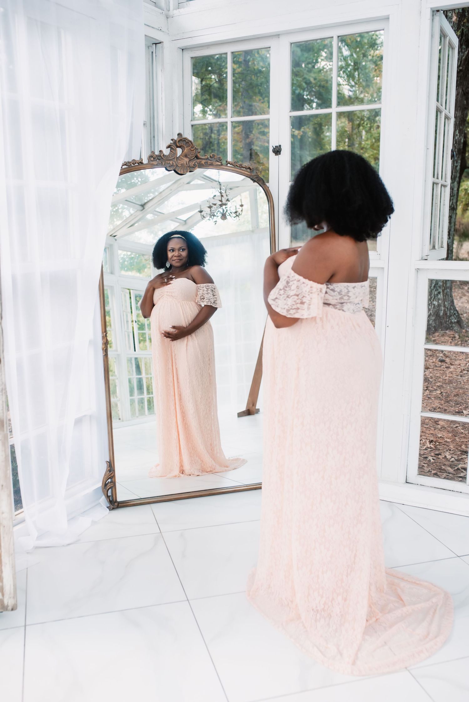 Expectant mother gazing in the mirror during maternity session in Houston.