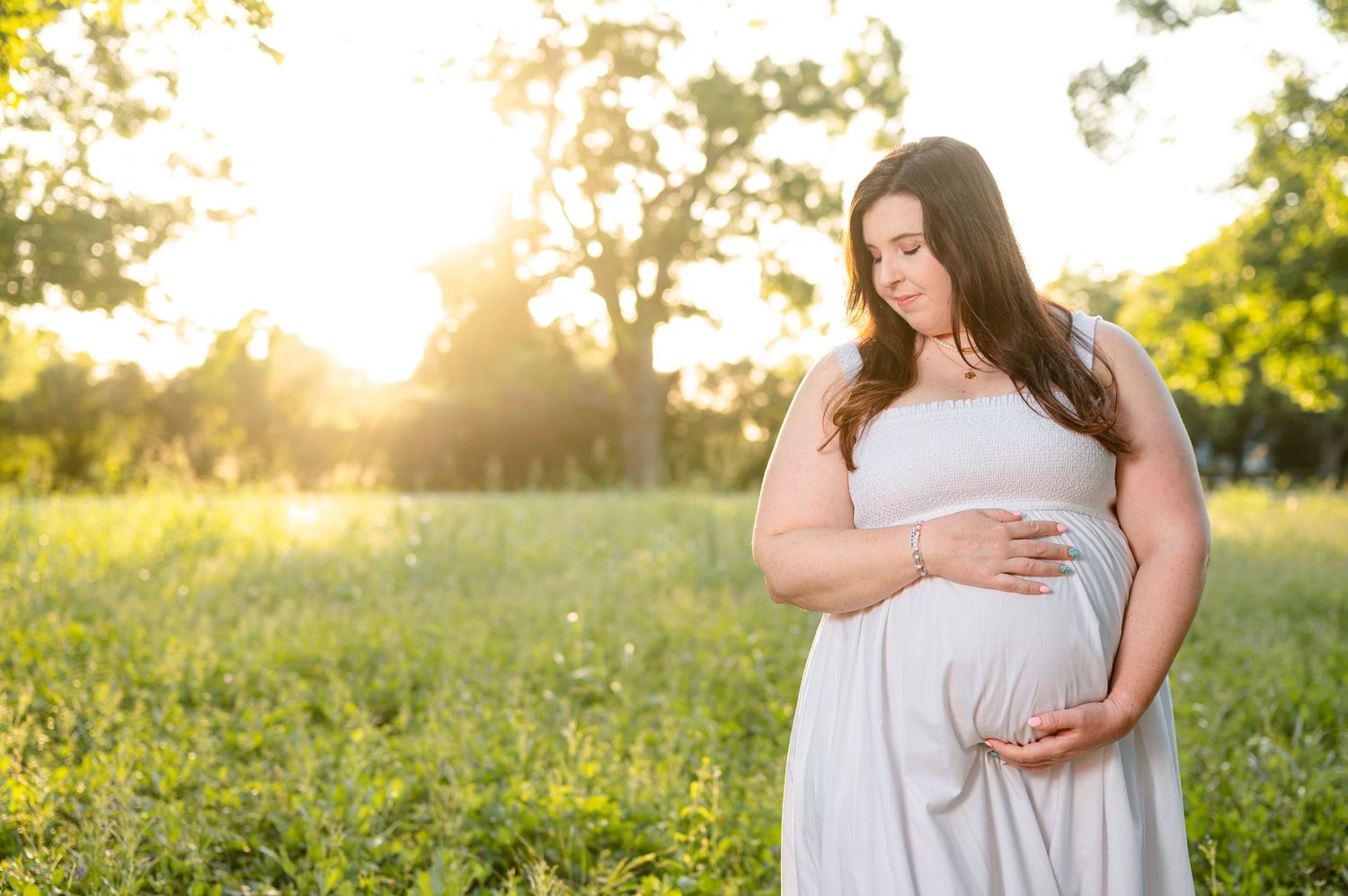 Expecting mother in neutral dress during maternity session in Fulshear, TX