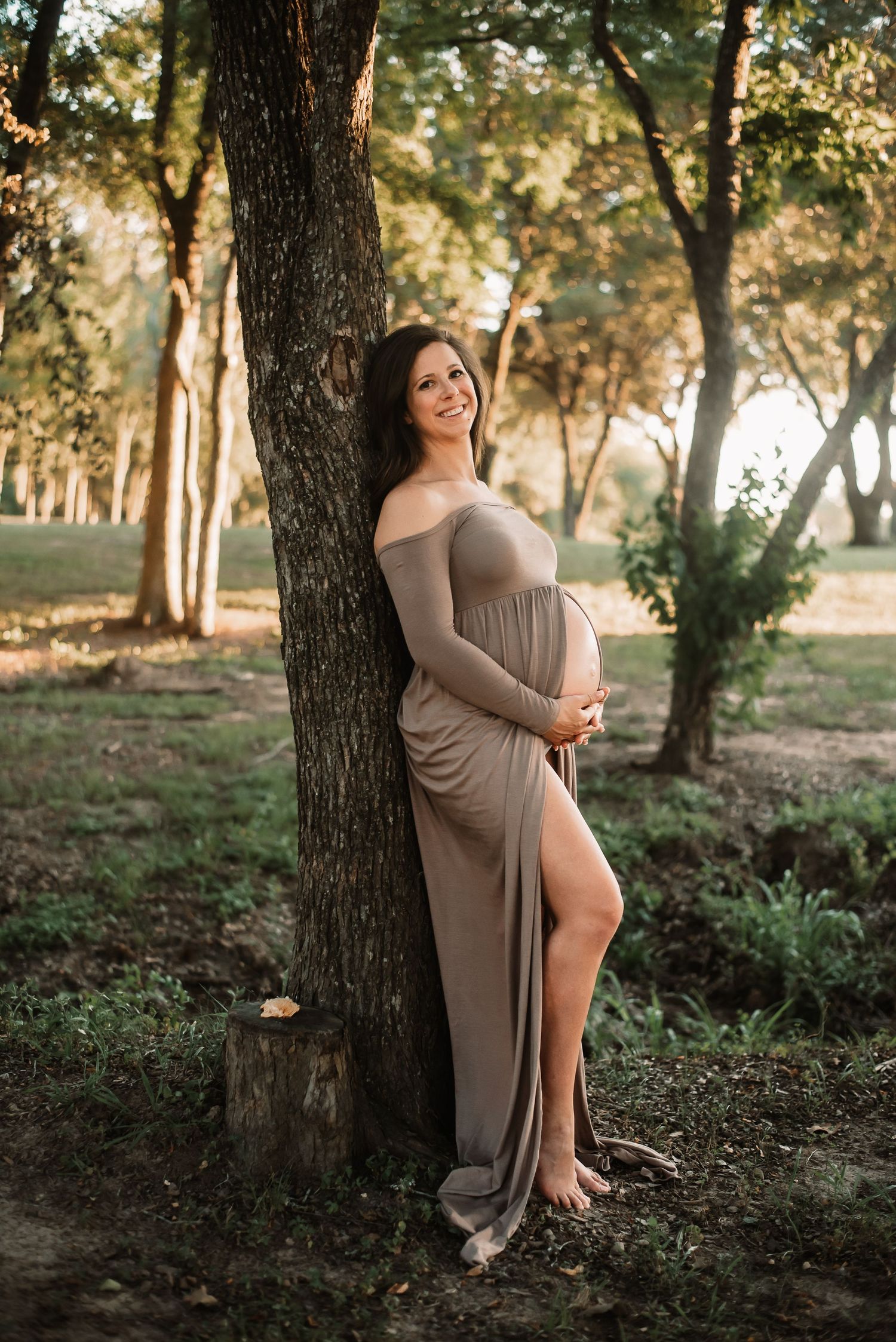 Outdoor maternity session of expectant mother holding her bump in Katy.