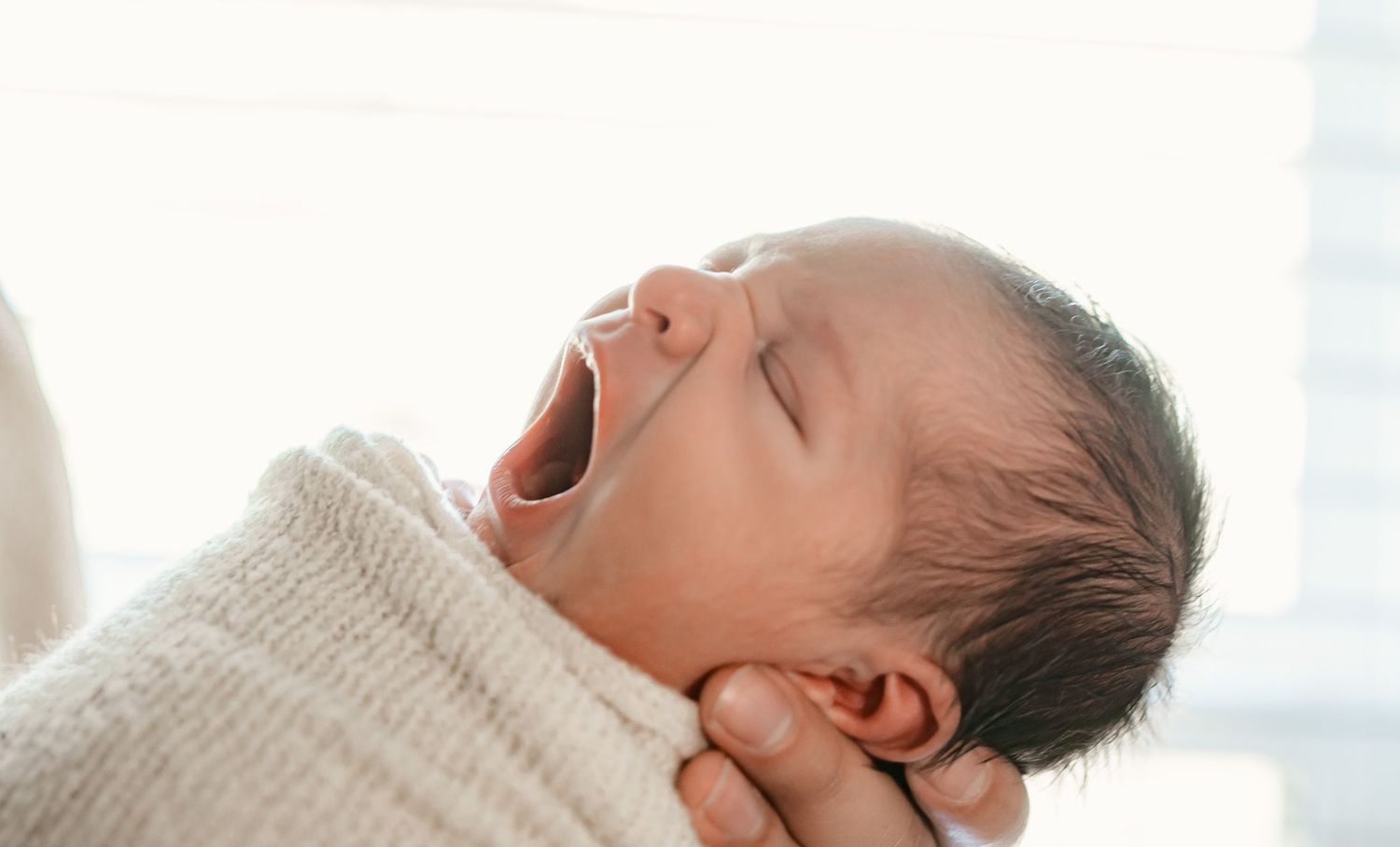 Studio session Fulshear, TX with a wrapped yawning newborn during the session.