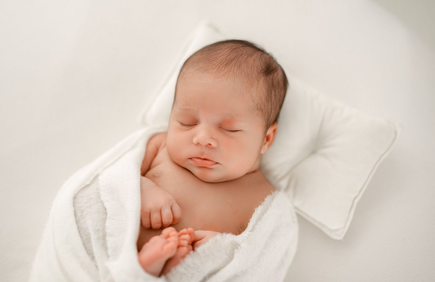 Peacefully sleeping newborn baby photographed in a soft natural light at Houston newborn photography studio.