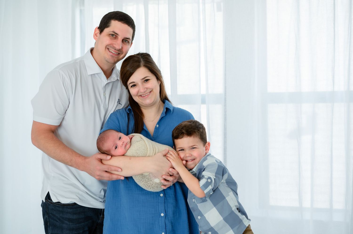 Family of 4 posing together during light and airy studio session in Katy Texas.