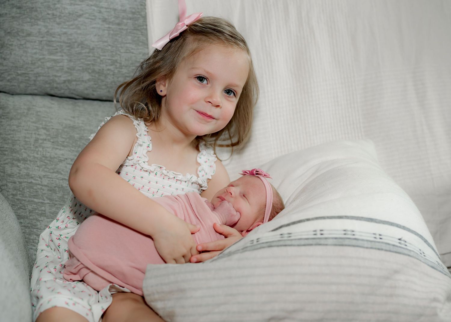 Proud sister snuggling her newborn sister during a Lifestyle newborn session in Houston TX