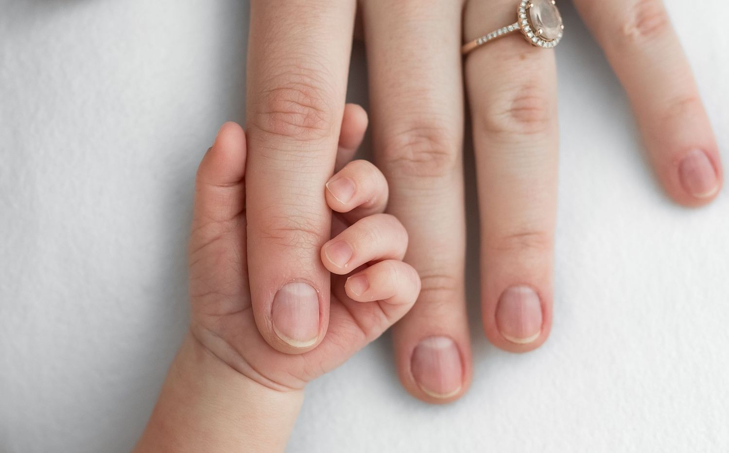 Newborn photography detail image of baby holding parent's finger in Katy, TX