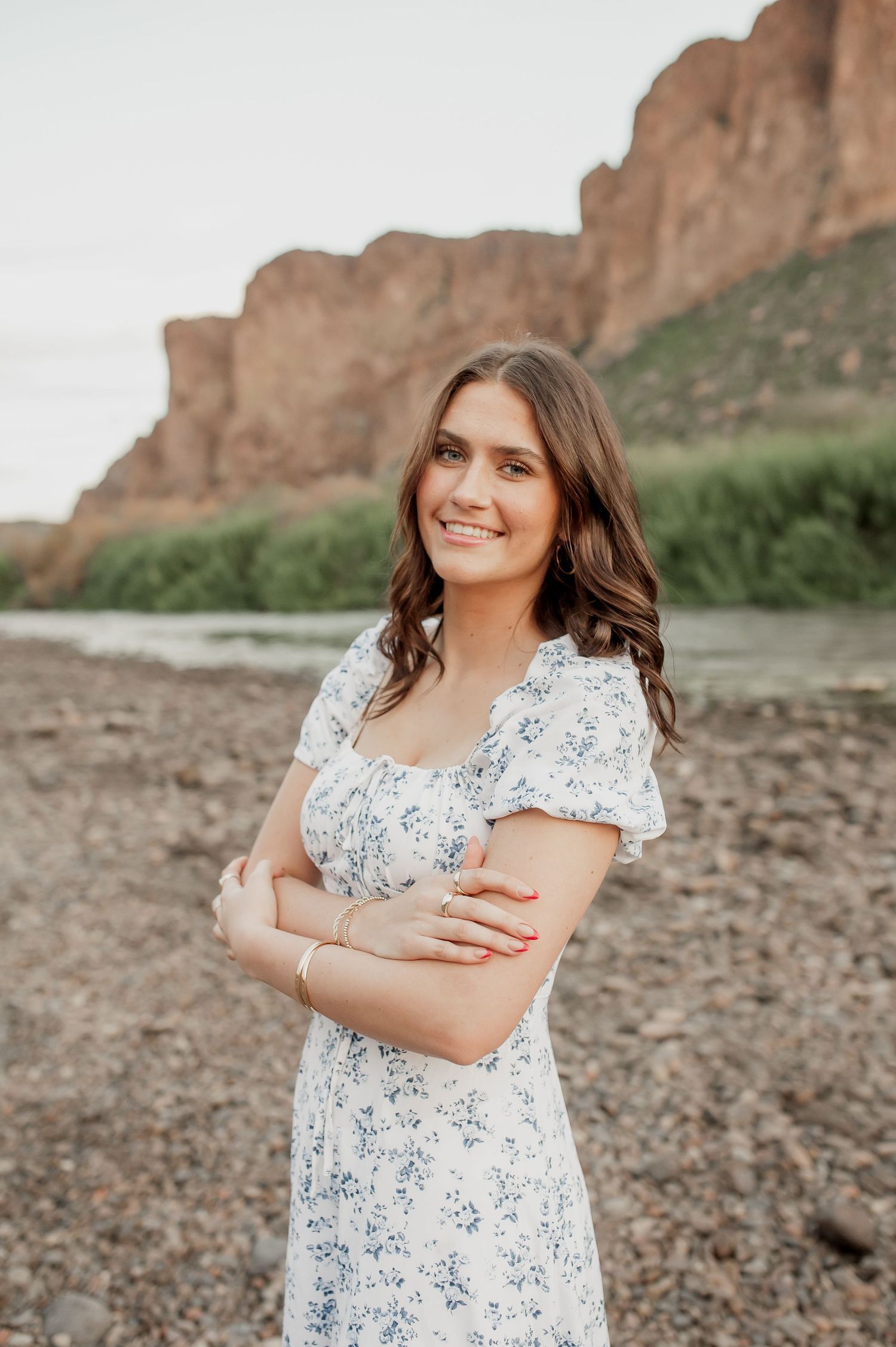 A white and blue floral dress stands out beautifully against the rocky desert landscape and canyon walls.