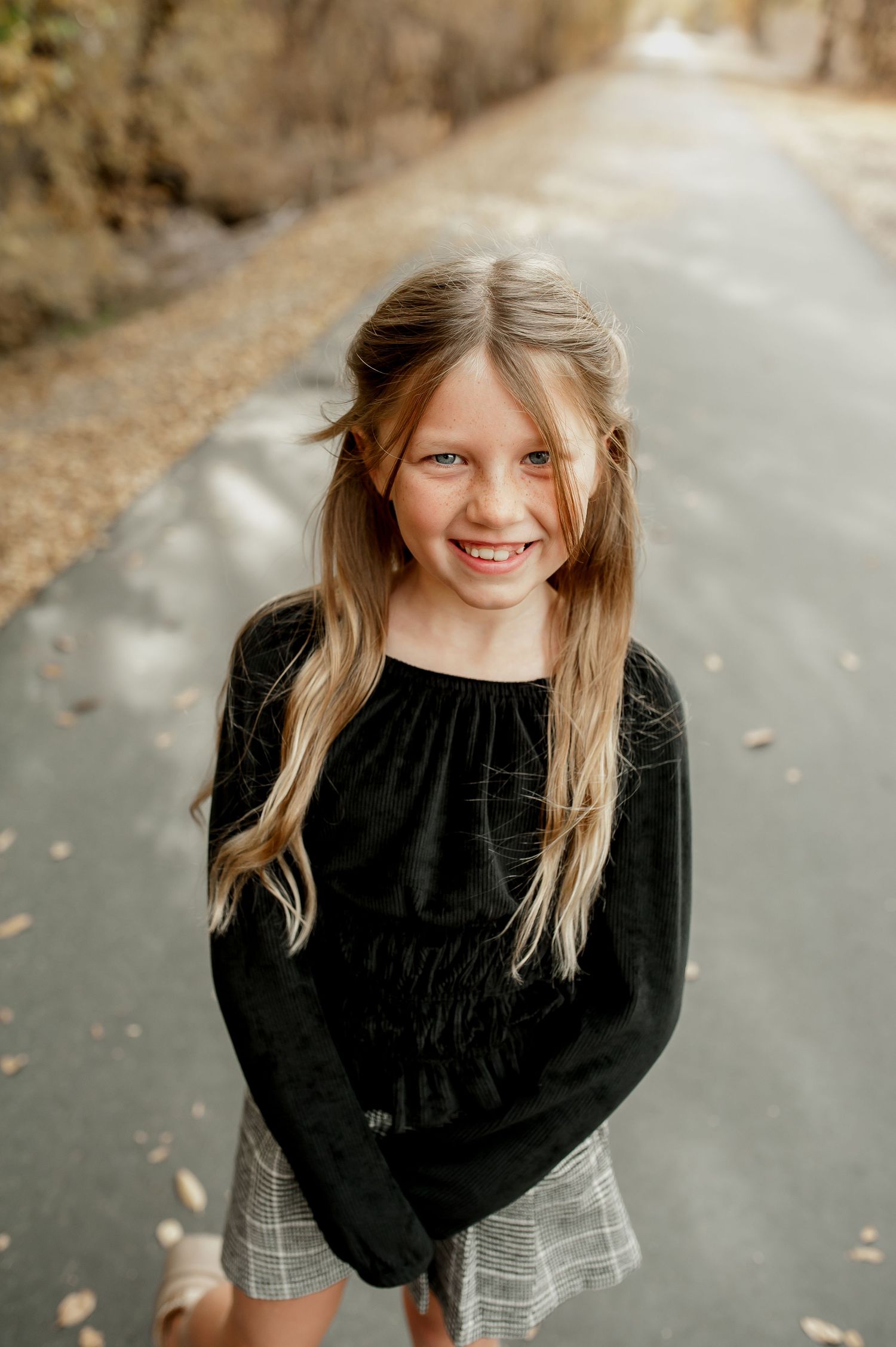 A series of outdoor portraits showing a child in a black sweater with blonde hair against a blurred natural background.