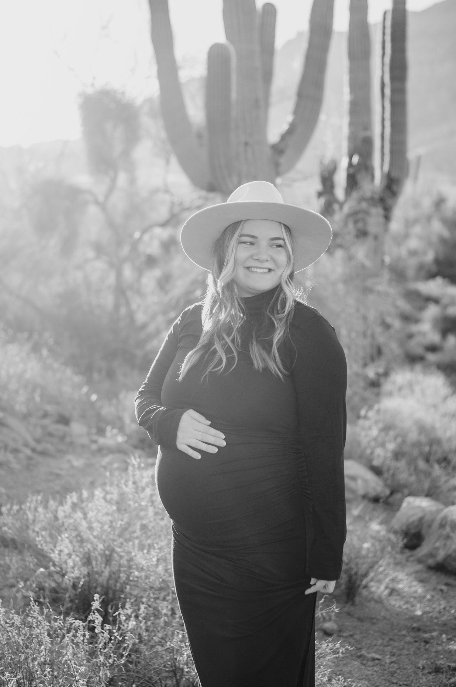 Black and white desert engagement photos with saguaro cacti in the background and soft natural lighting.