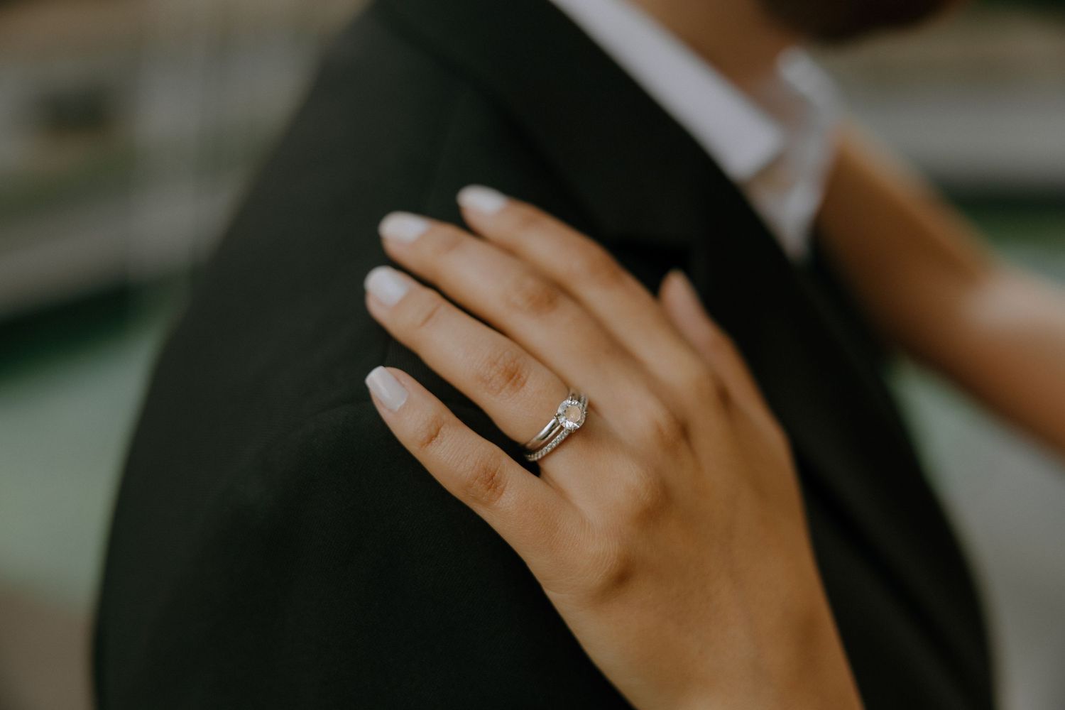 Close-up detail of hands and engagement ring during romantic moment.