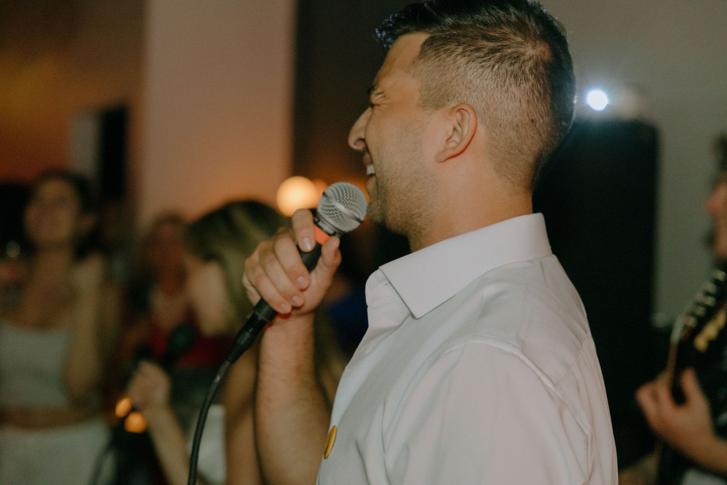 Guests enjoying themselves on a dark dance floor at an evening celebration.