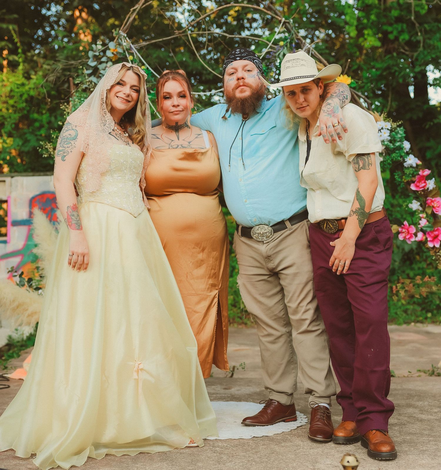 Wedding party poses together outdoors in coordinated formal attire.