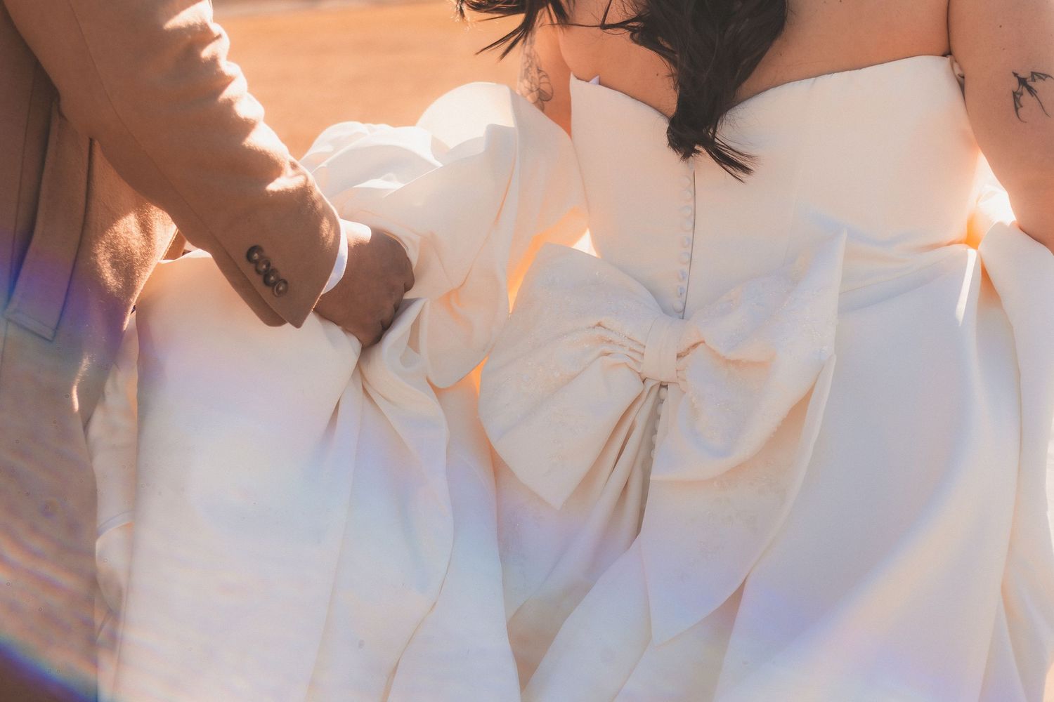 Dreamy wedding photography featuring flowing white dress details in natural light.