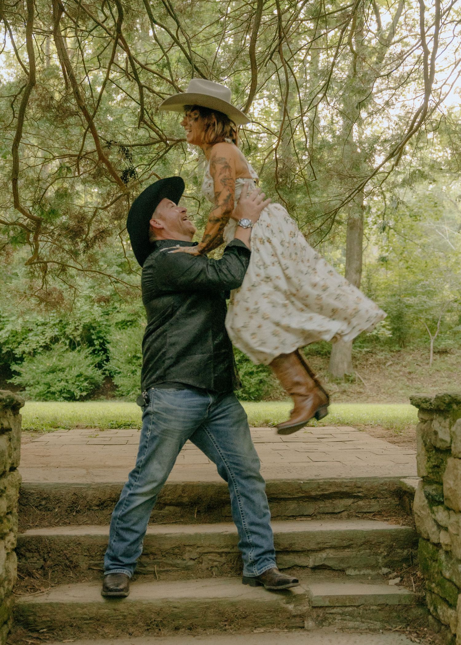 Dancing together on a rustic stone wall in a wooded setting.