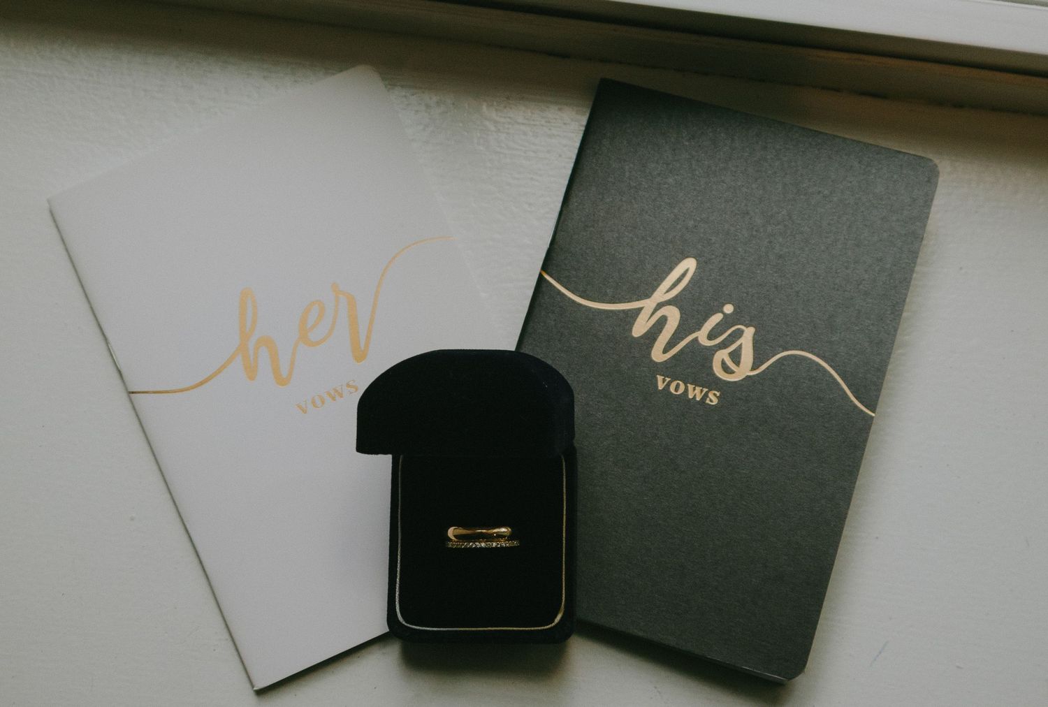 Black and gold stationery items including cards, envelopes and gift boxes arranged on a white surface.