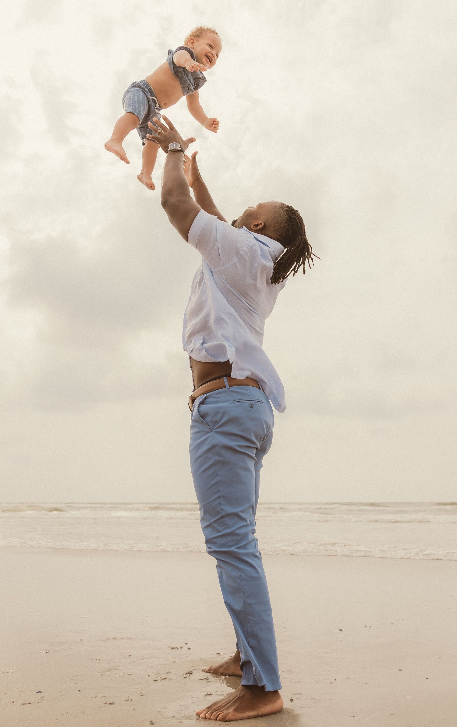 Sequence of playful moments showing a toddler being lifted in the air on a misty beach.
