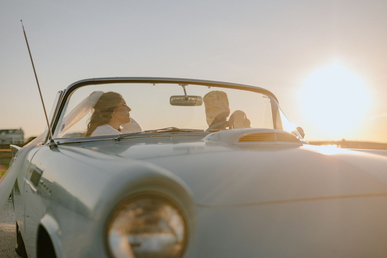 Sunlight streaming through classic car windshield during golden hour.