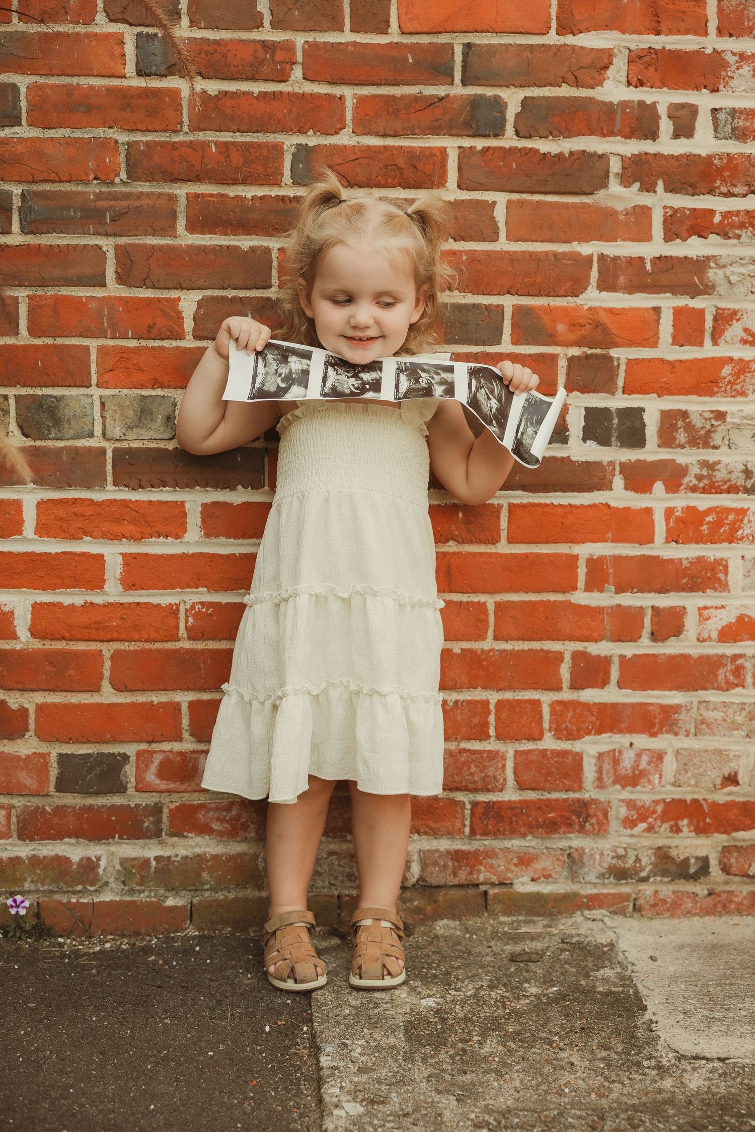 Series of cropped photos showing cream dresses against red brick wall background.