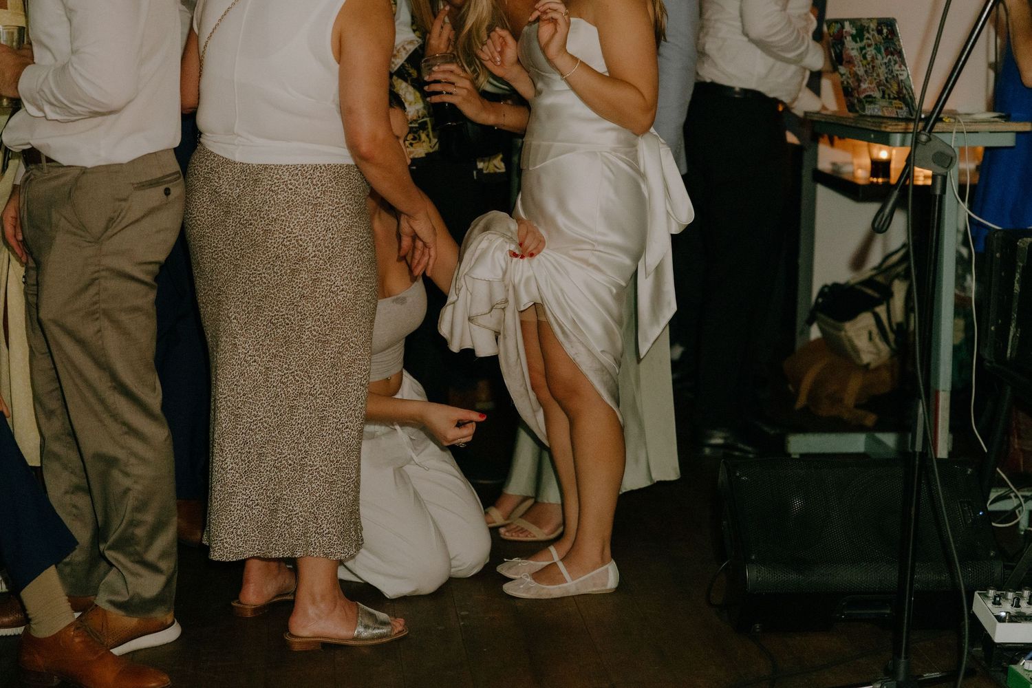 People's legs and feet visible at a party gathering.
