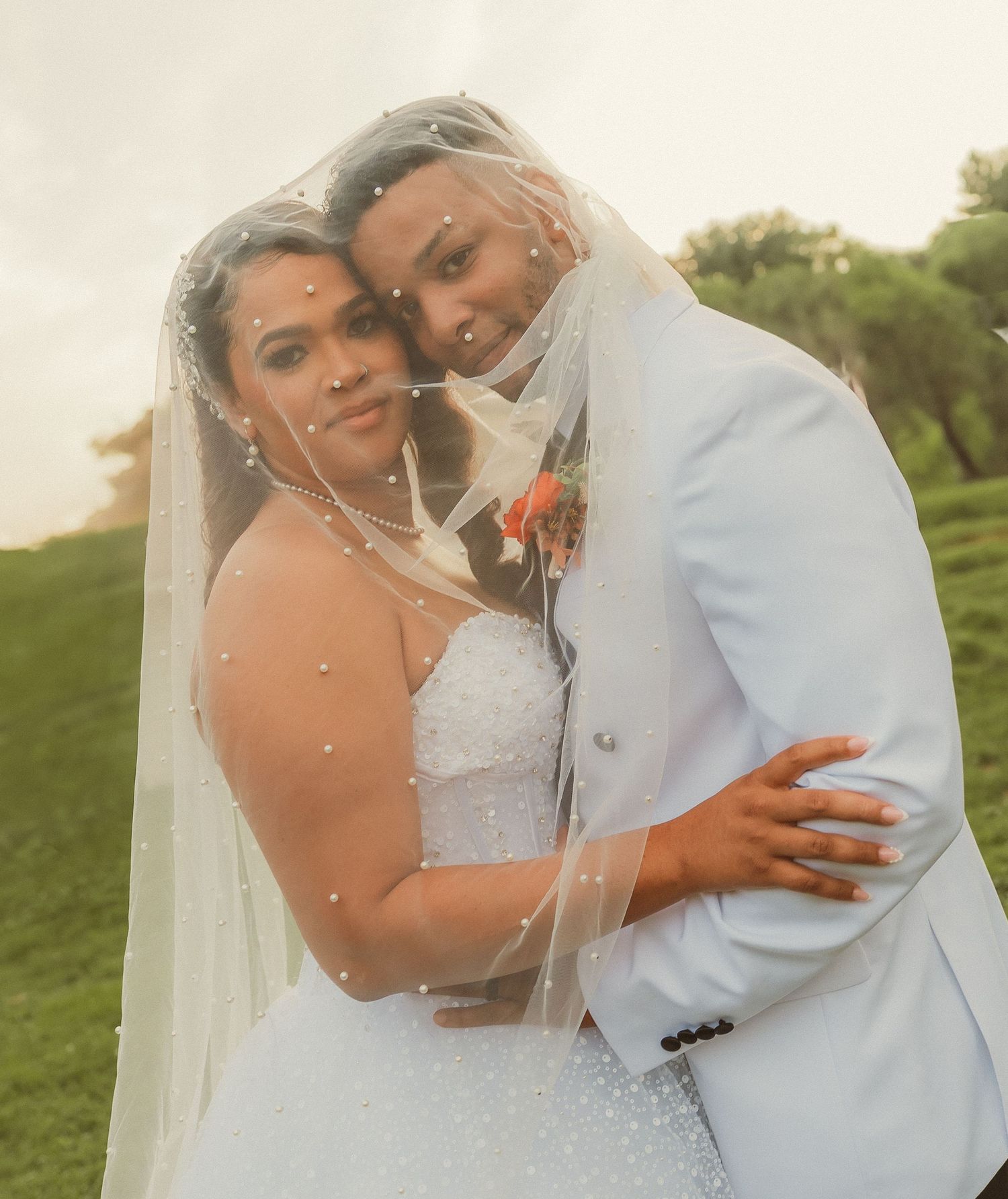 A couple in wedding attire embrace outdoors in a series of romantic sunset photos.