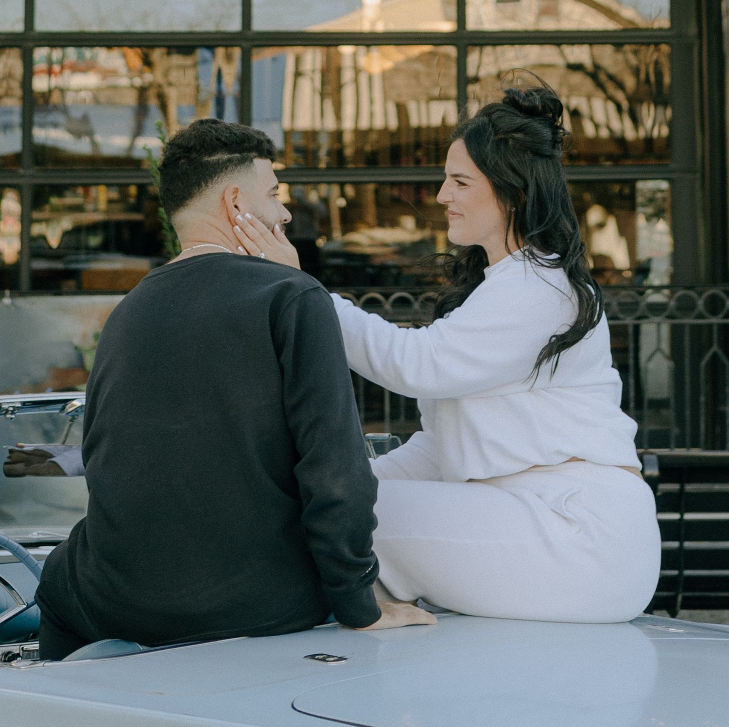 Couple sitting on outdoor patio bench showing progressive stages of affectionate interaction at sunset.