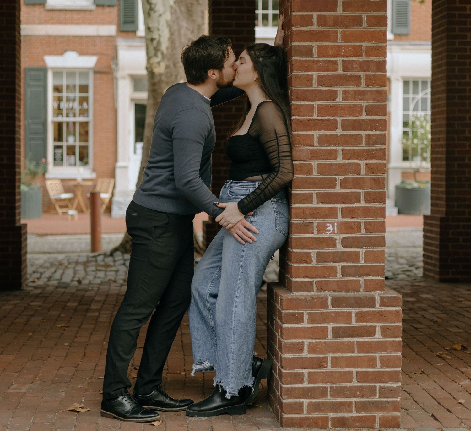 A couple shares intimate moments in a series of romantic photos against a brick wall backdrop.