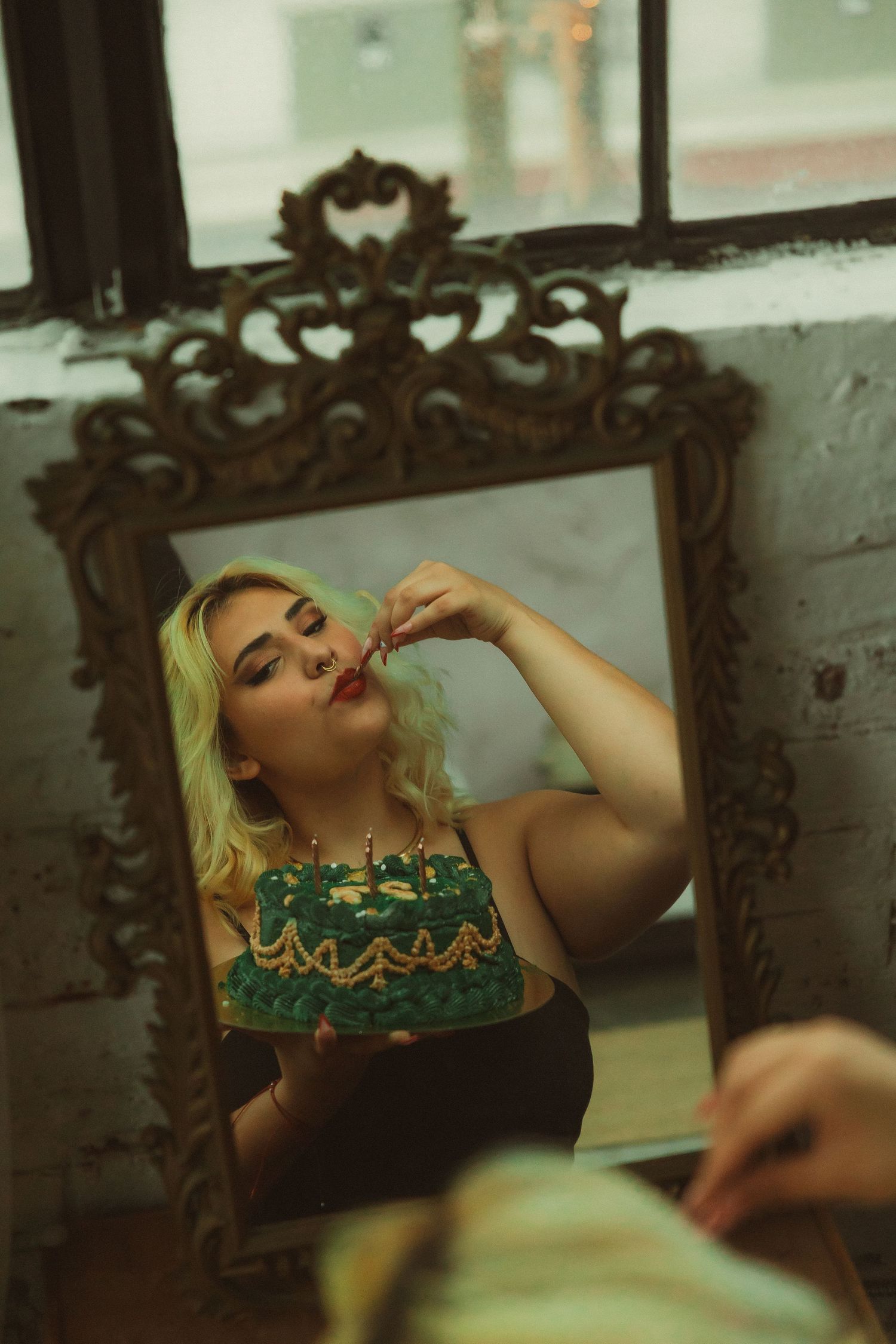 Green cake reflected in ornate vintage mirror.