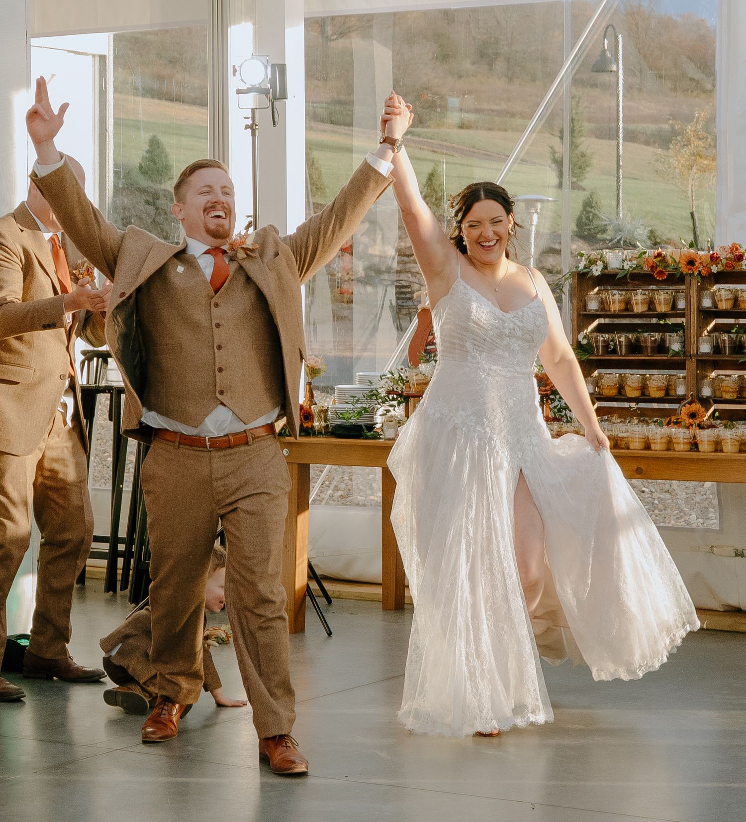 Wedding celebration with dancing in bright indoor venue with rustic decor.