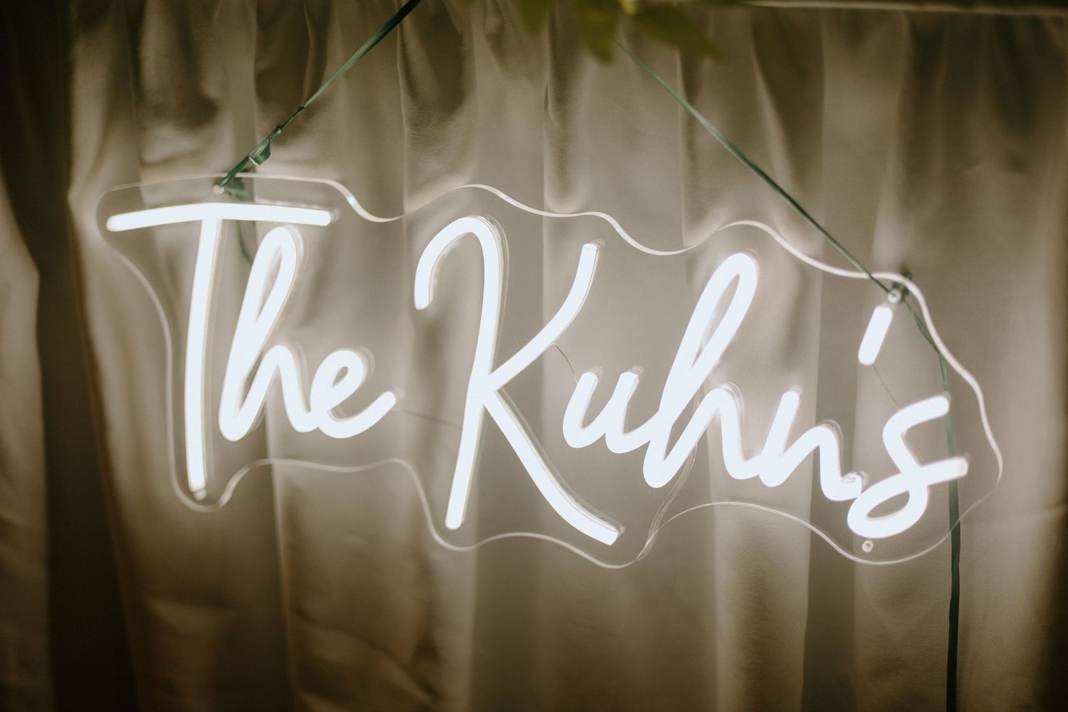 Illuminated white neon sign text glowing against a dark wall background.