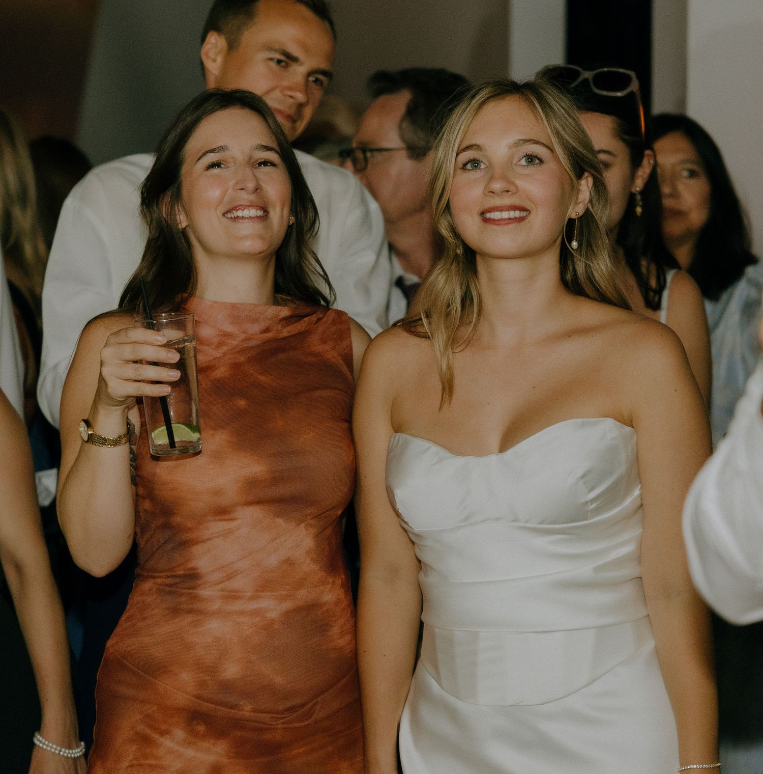 Wedding reception guests dancing and celebrating in formal attire.