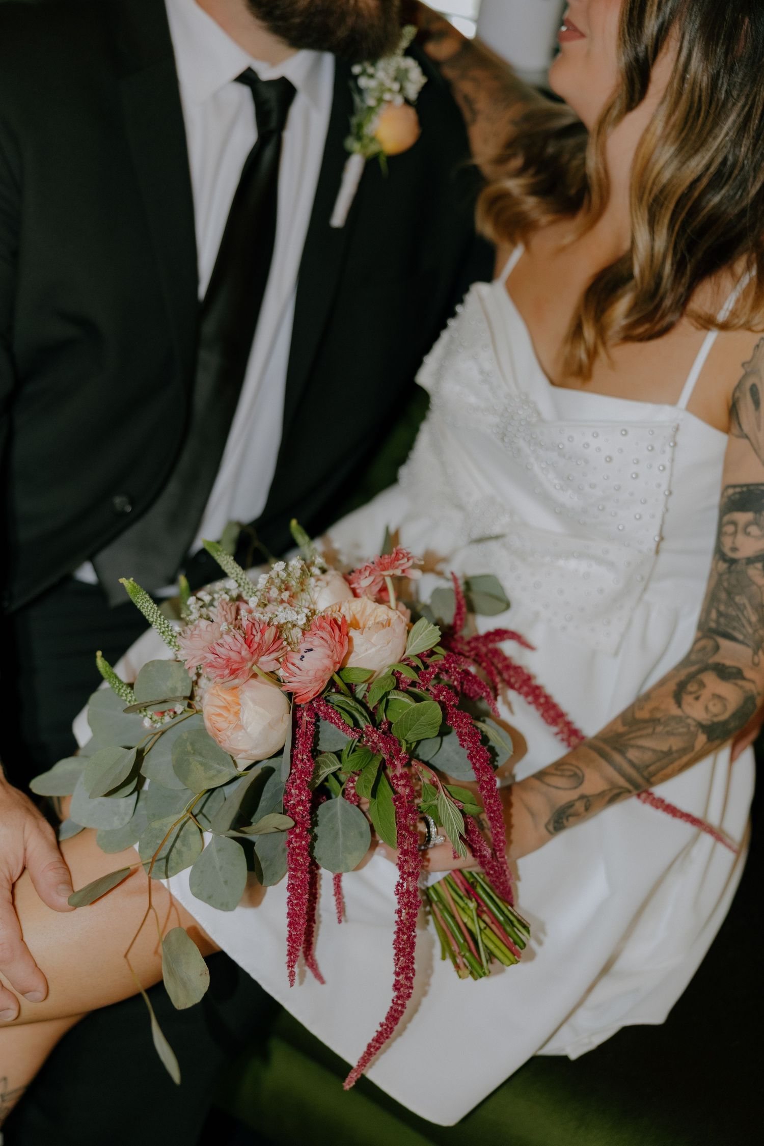 Wedding detail photo of floral bouquet with pink and green botanical elements.