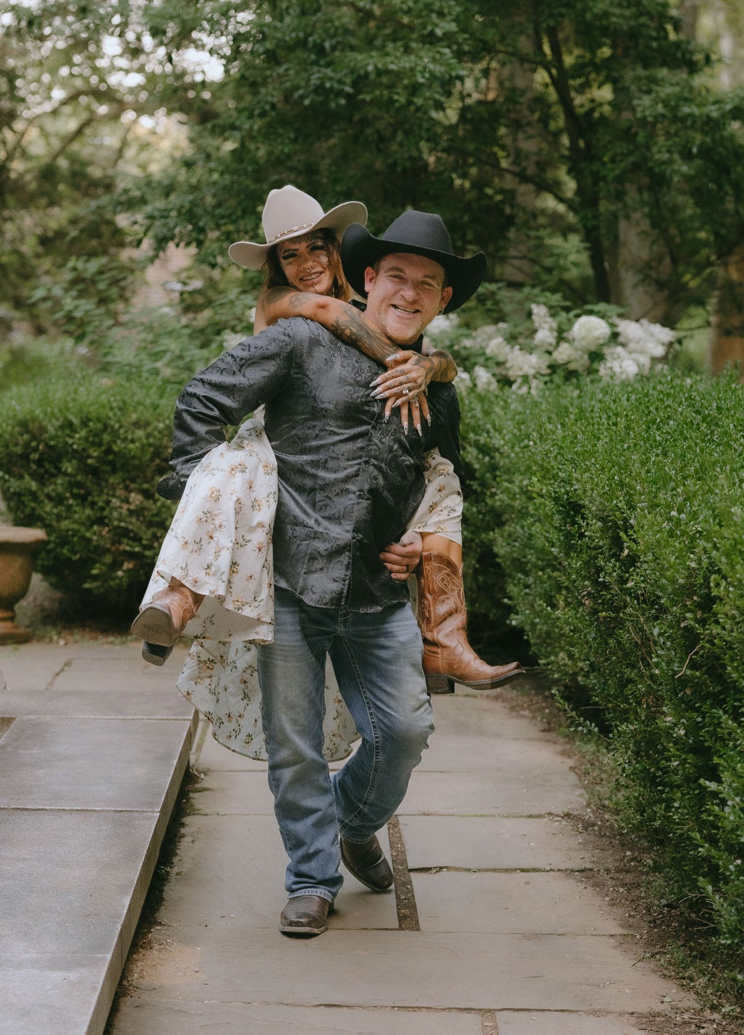 Intimate dance moves captured along a garden pathway.