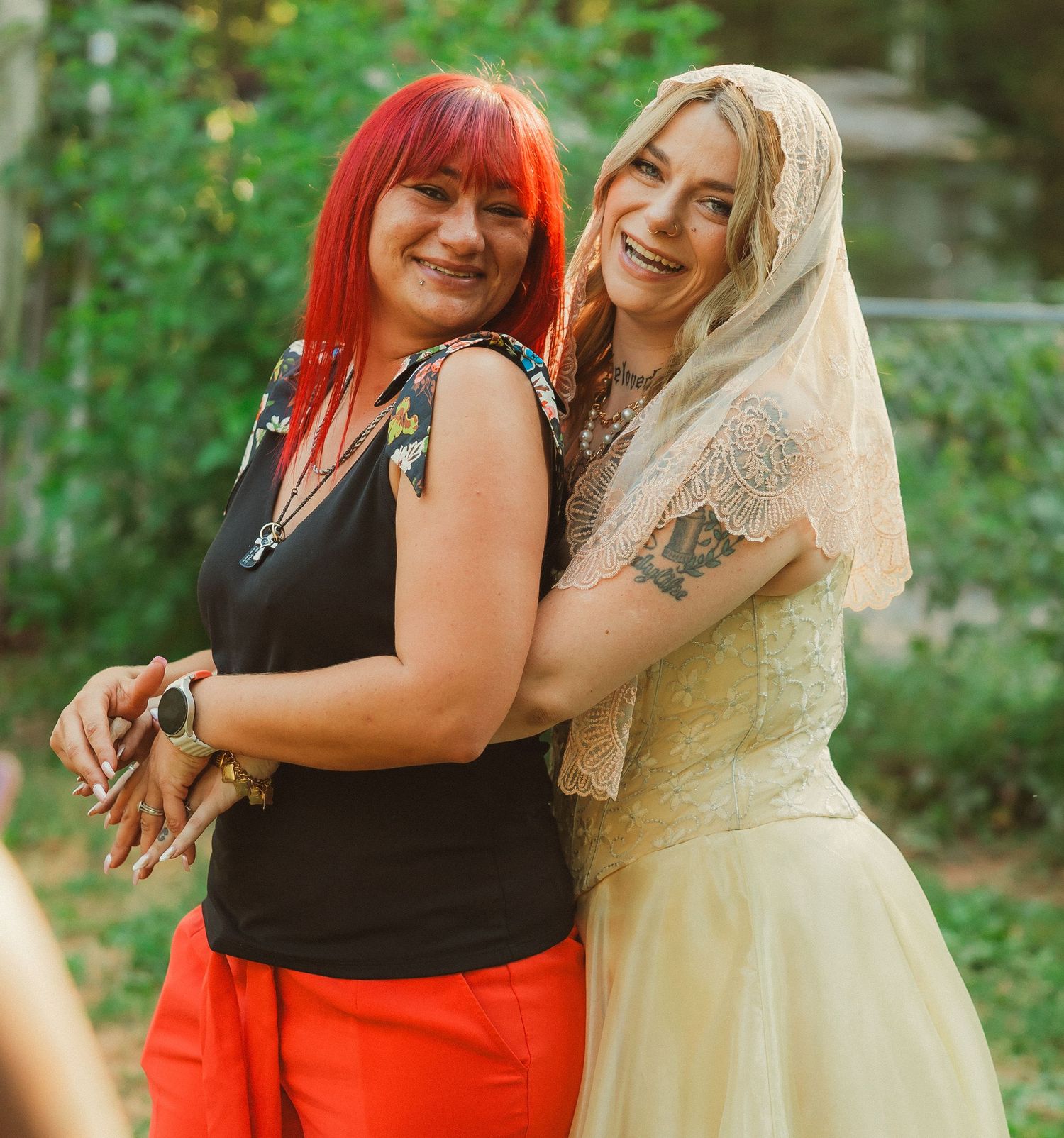 Two people embracing and celebrating during an outdoor wedding photoshoot.