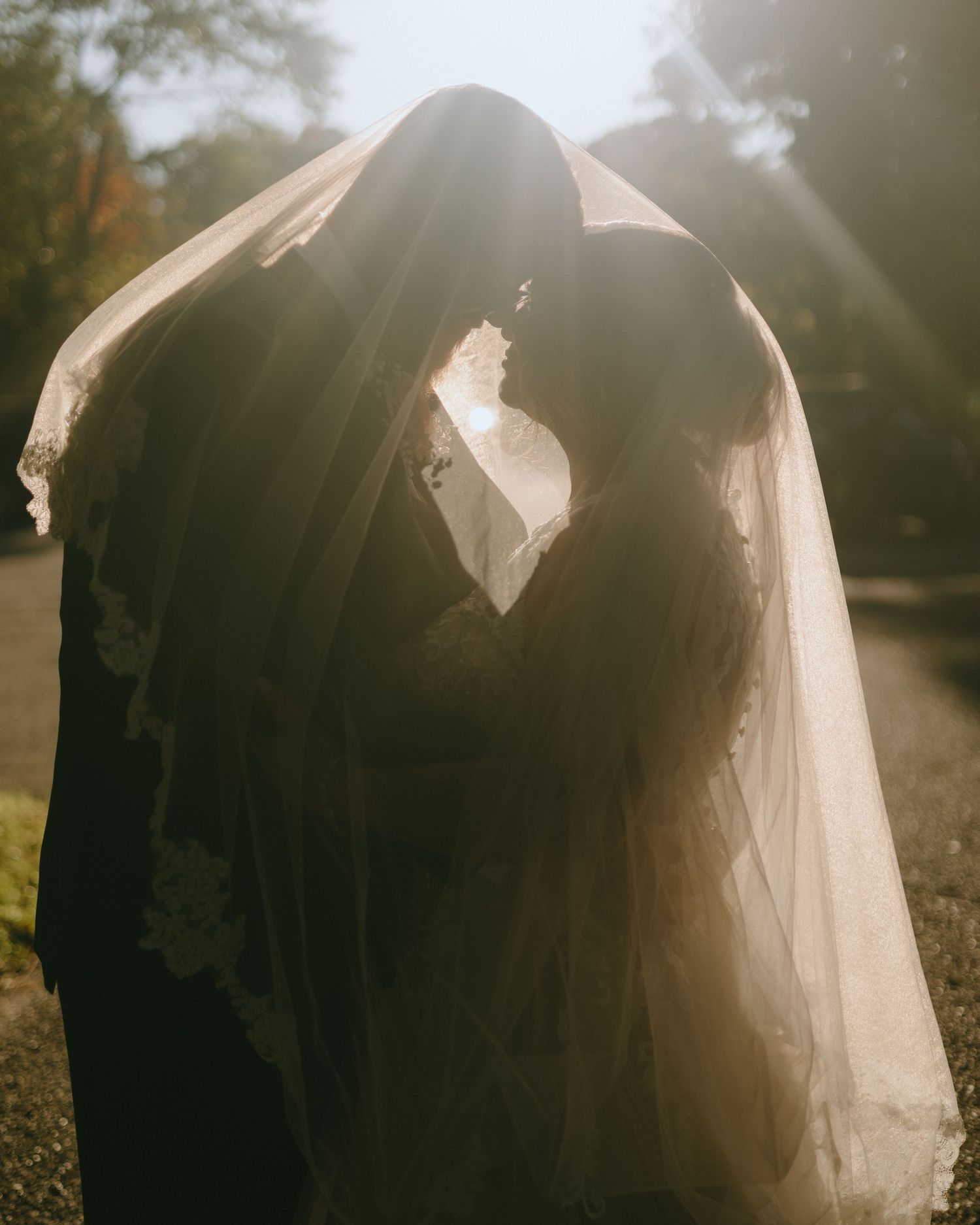 Ethereal silhouettes of wedding attire captured in dreamy backlit sunset lighting.