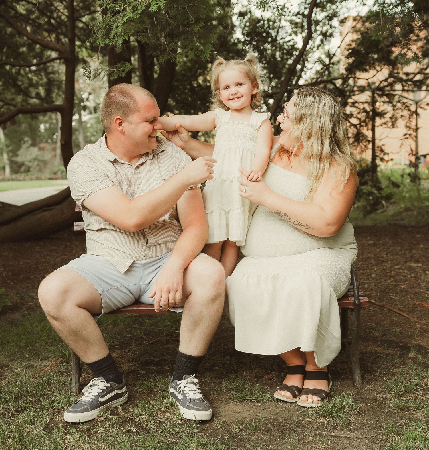 Candid family moments captured in warm evening light under trees.