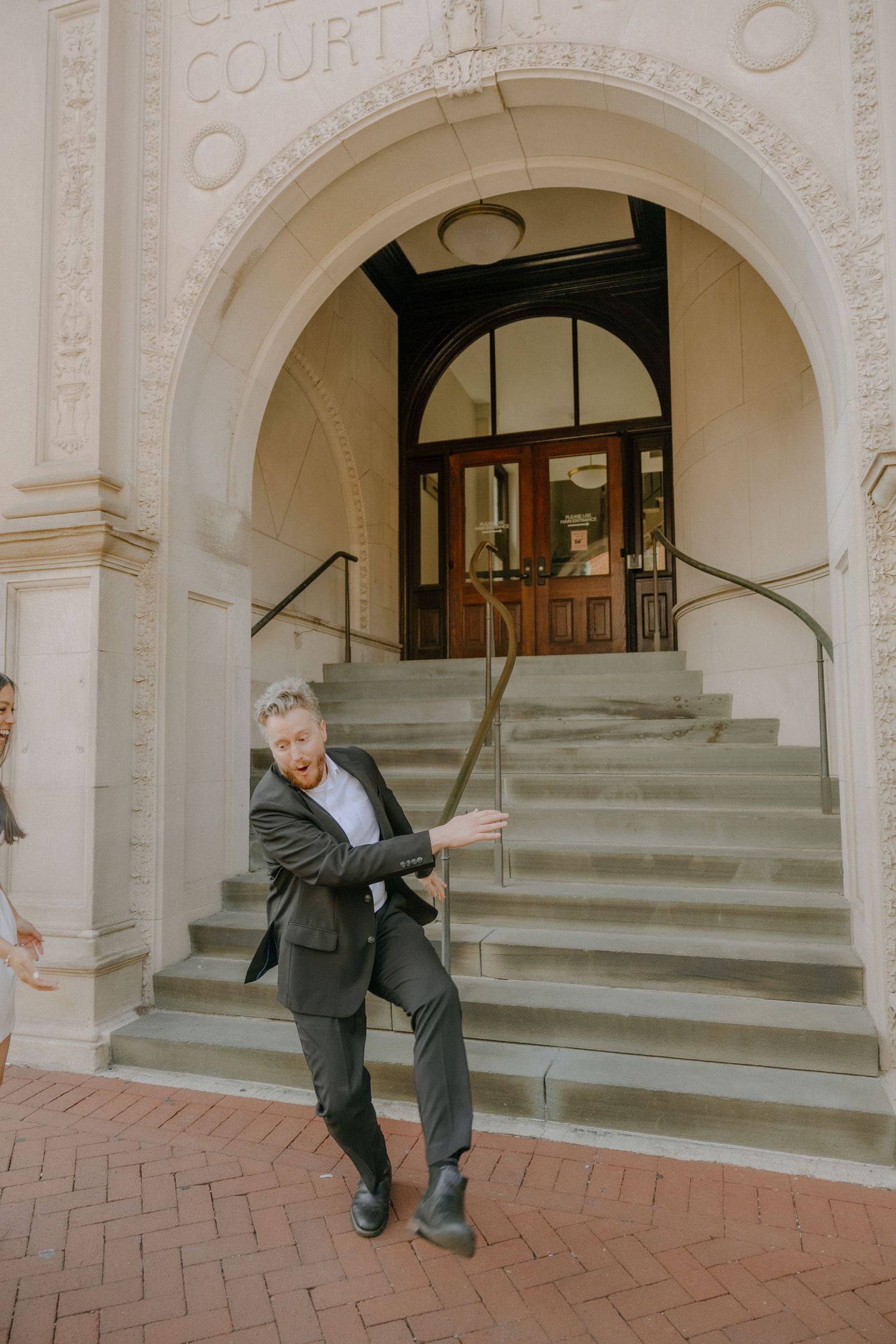 Series of images showing movement across the stone steps of a historic courthouse entrance.