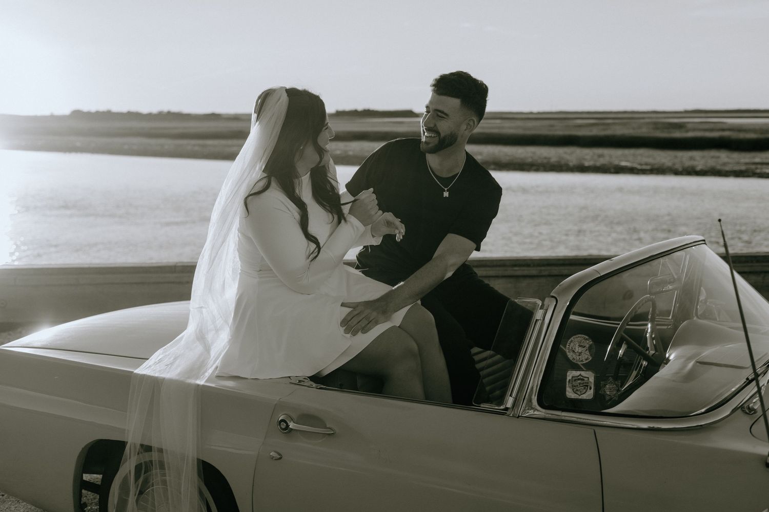 A black and white photo sequence showing a couple in a vintage car sharing a romantic moment together.