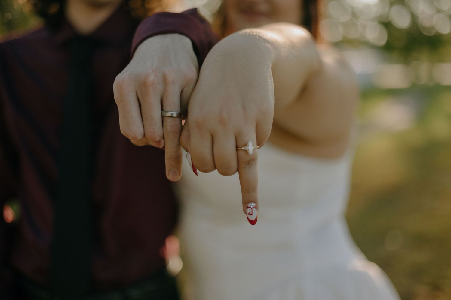 Close-up of hands showing off wedding rings during a celebration.