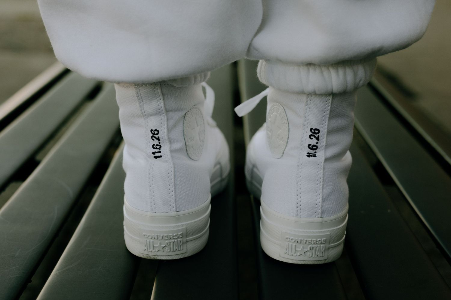 A close-up view of white ceramic doll legs and feet standing on a dark surface.